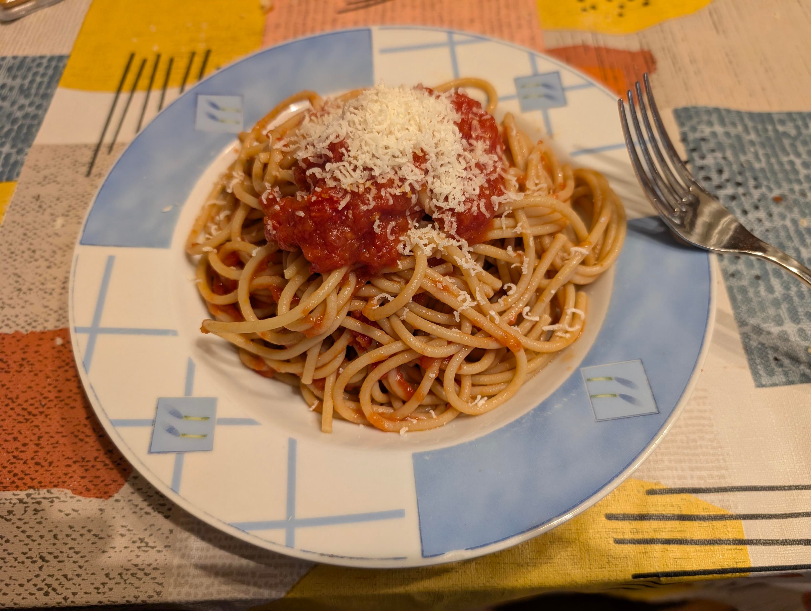A dish of spaghetti, with tomato sauce and some parmigiano. I'll add much more parmigiano, as I love it. 