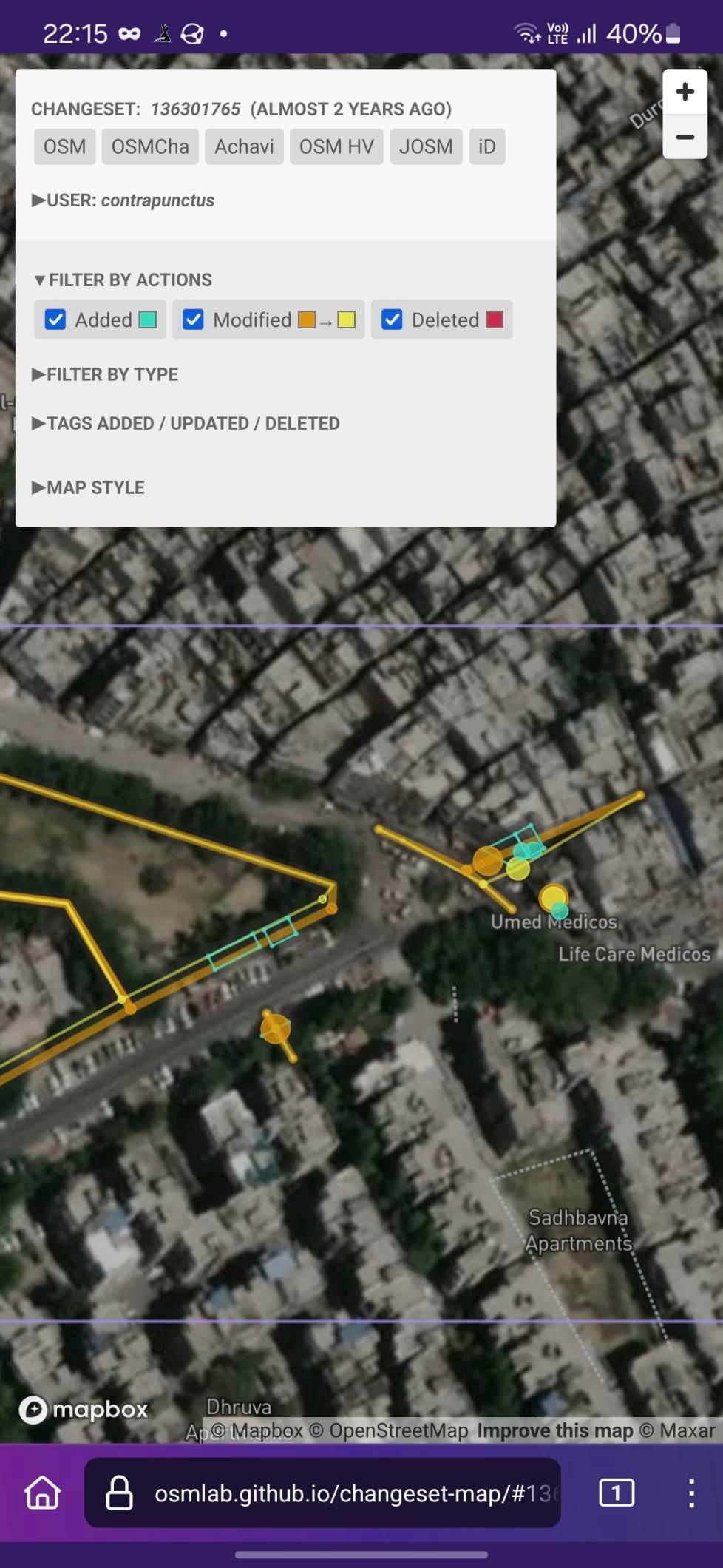 Screenshot of Changeset Map, visualizing the changes made against a satellite imagery background. Among other changes, I've added two buildings to the left - the Aam Aadmi Mohalla Clinic and a dumpster - and two apartment buildings across the junction to the right.