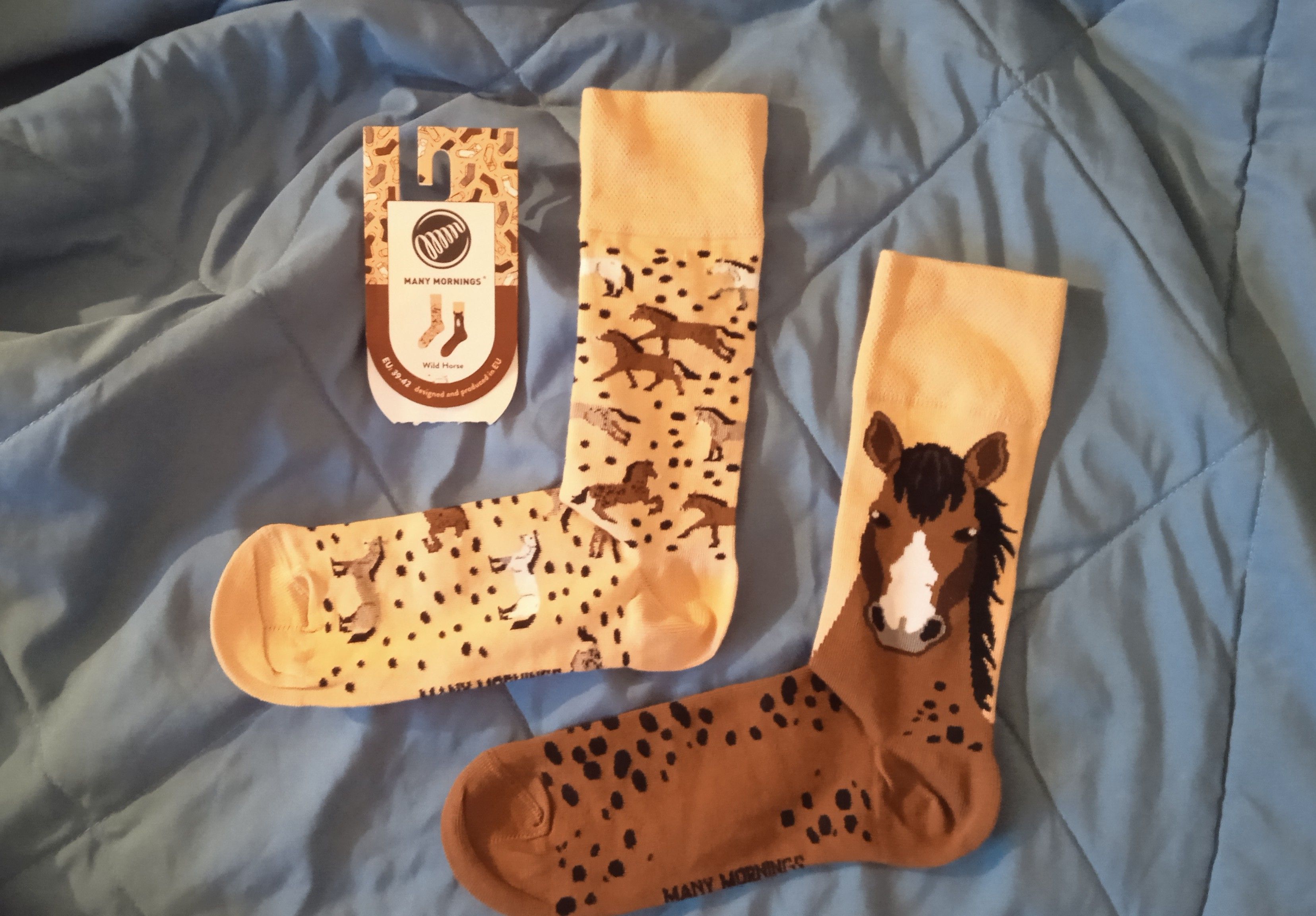 A pair of yellow socks with brown horses printed on