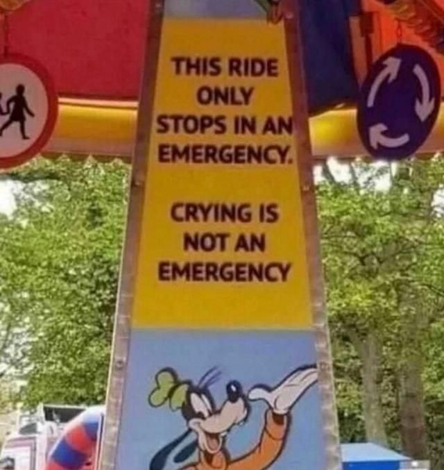 A picture of a sign from a carousel attraction. Black text on yellow says: "This ride only stops in an emergency. Crying is not an emerge ch" 