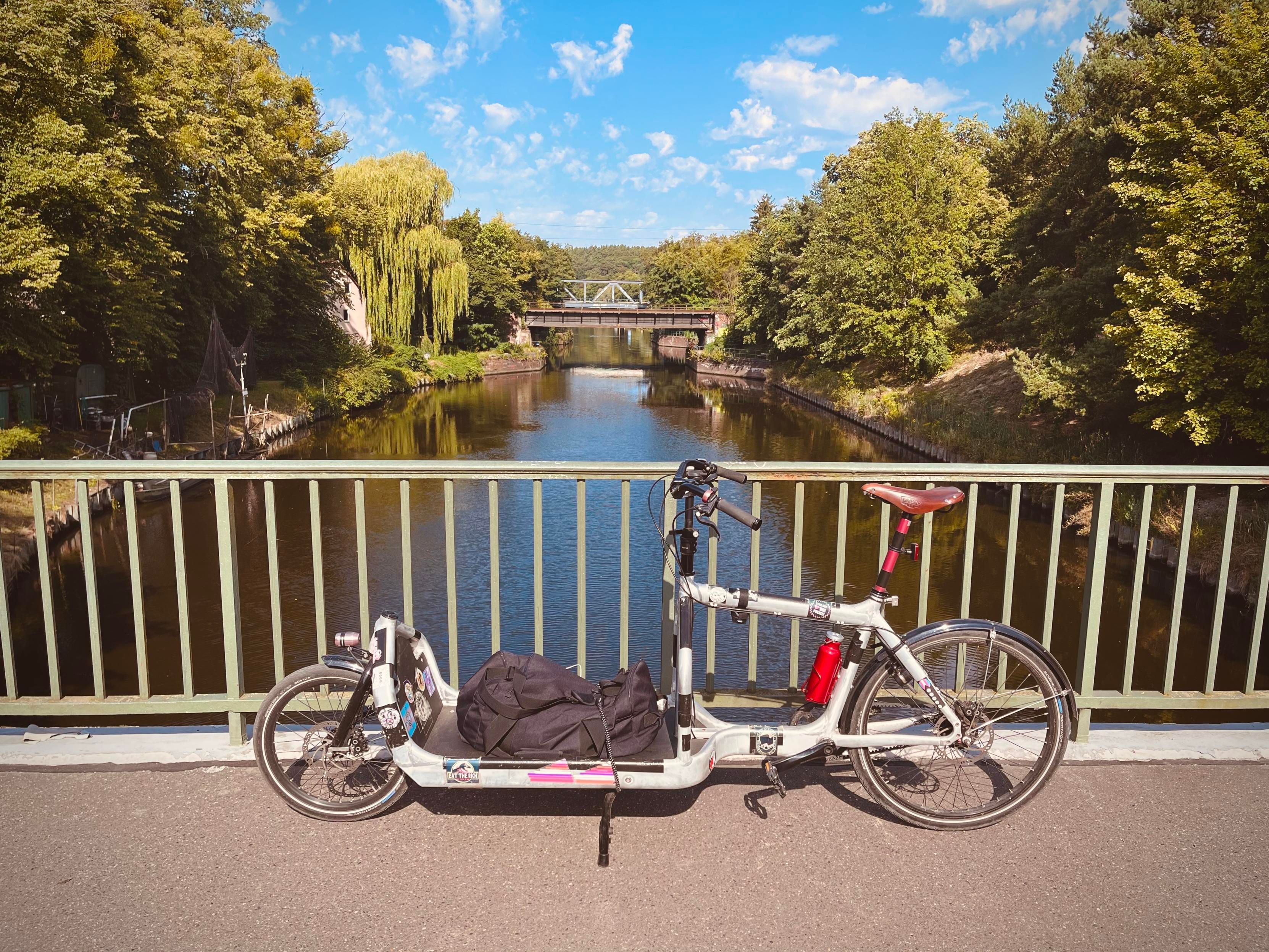 Cargo bike parked on a bridge over a canal with another bridge in the background
