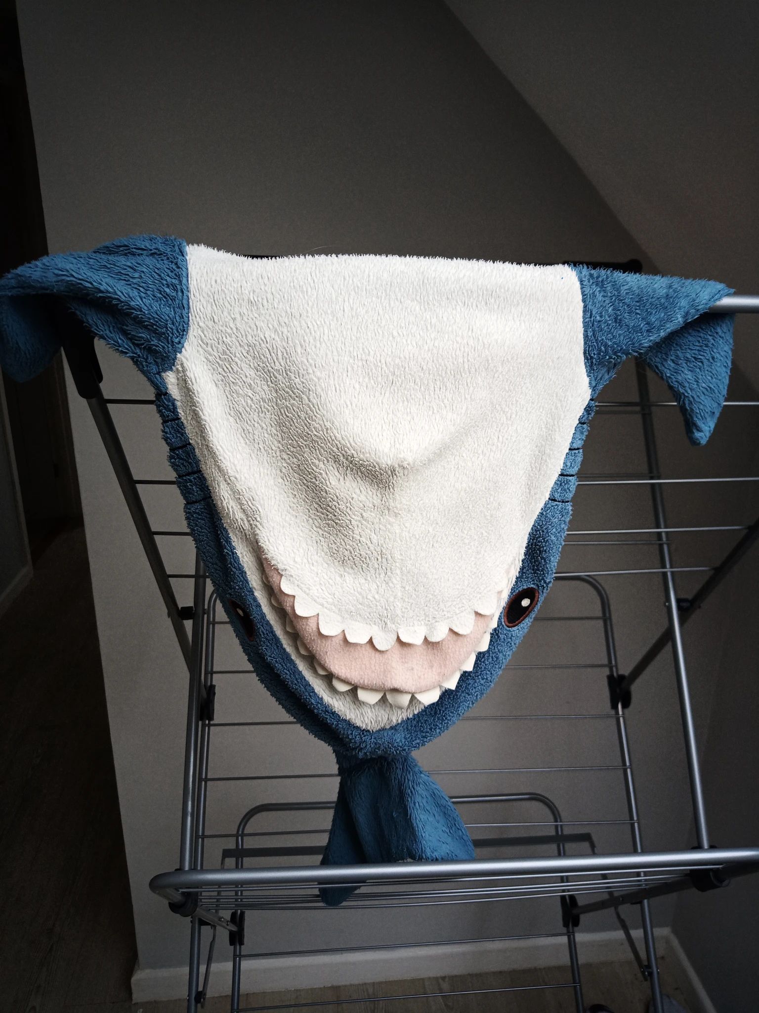 blahaj having a rest on the drying rack