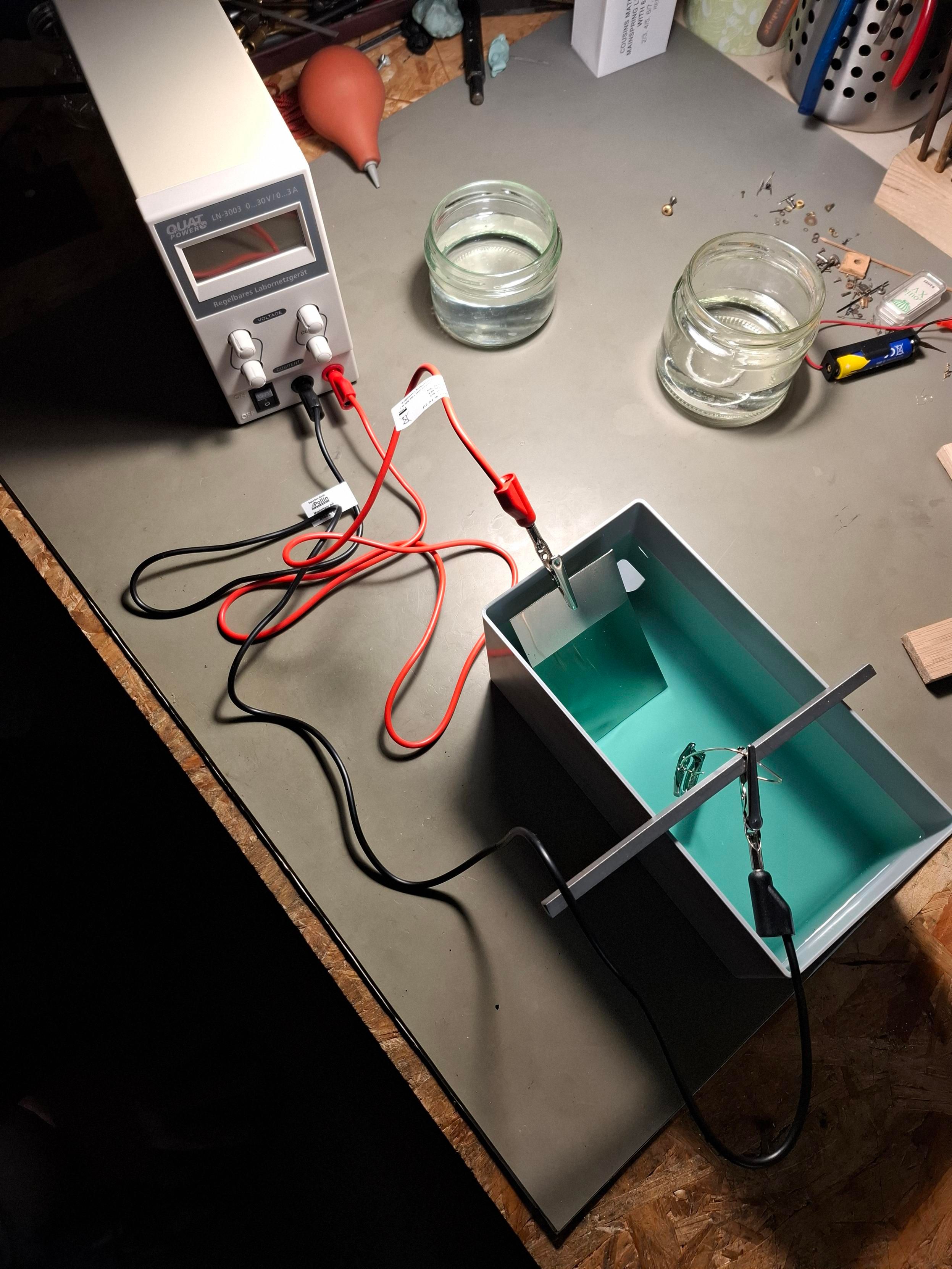 Nickelage d'un boitier dans un bain avec une anode tenant une tôle fe nickel et une cathode tenant le boitier à nickeler. 