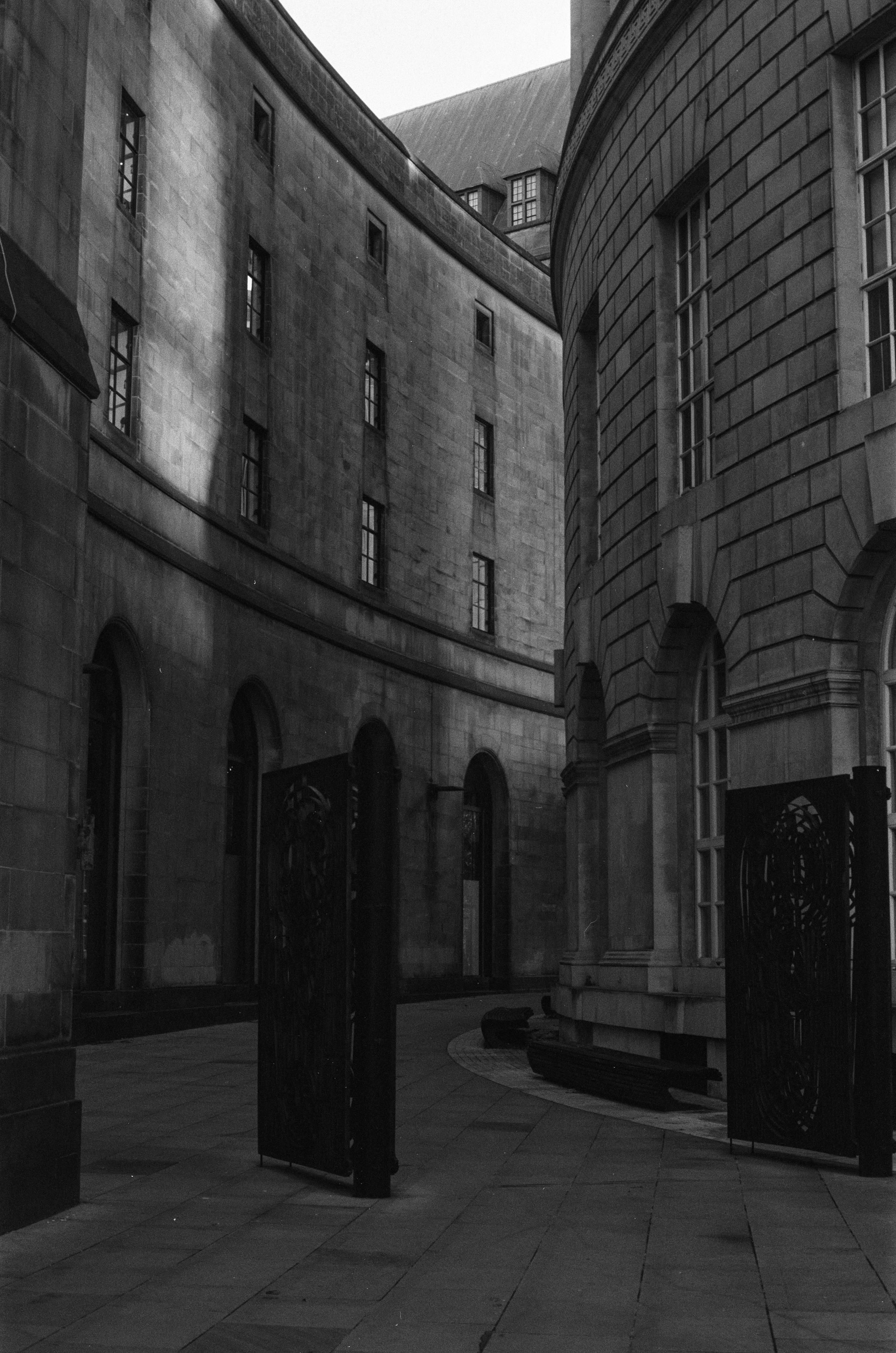 A curved passageway behind a round building.