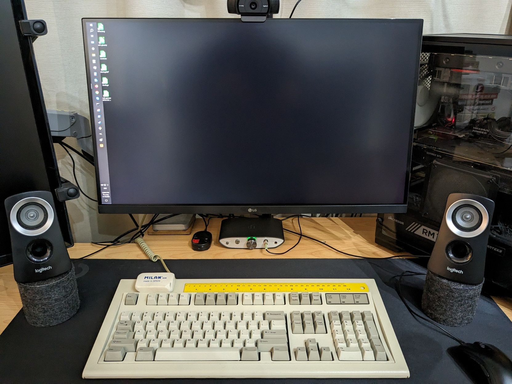 Computer desktop setup, with logitech speakers placed symmetrically on some cylindrical stands, at about arm's length from each other (~70 cm or 2.3 feet) as well as each one at that same distance from the point of view of the camera, which is where my head normally is when using this computer.
