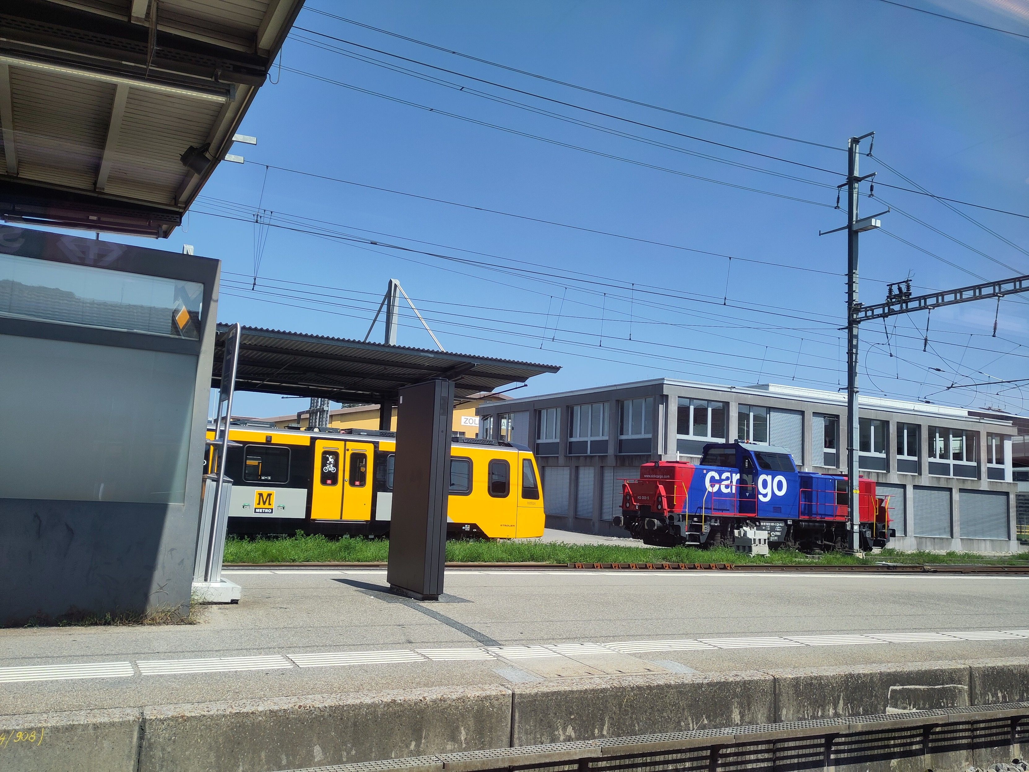 Foto. Eine gelbe Metro und eine Rangierlok im Bahnhof.