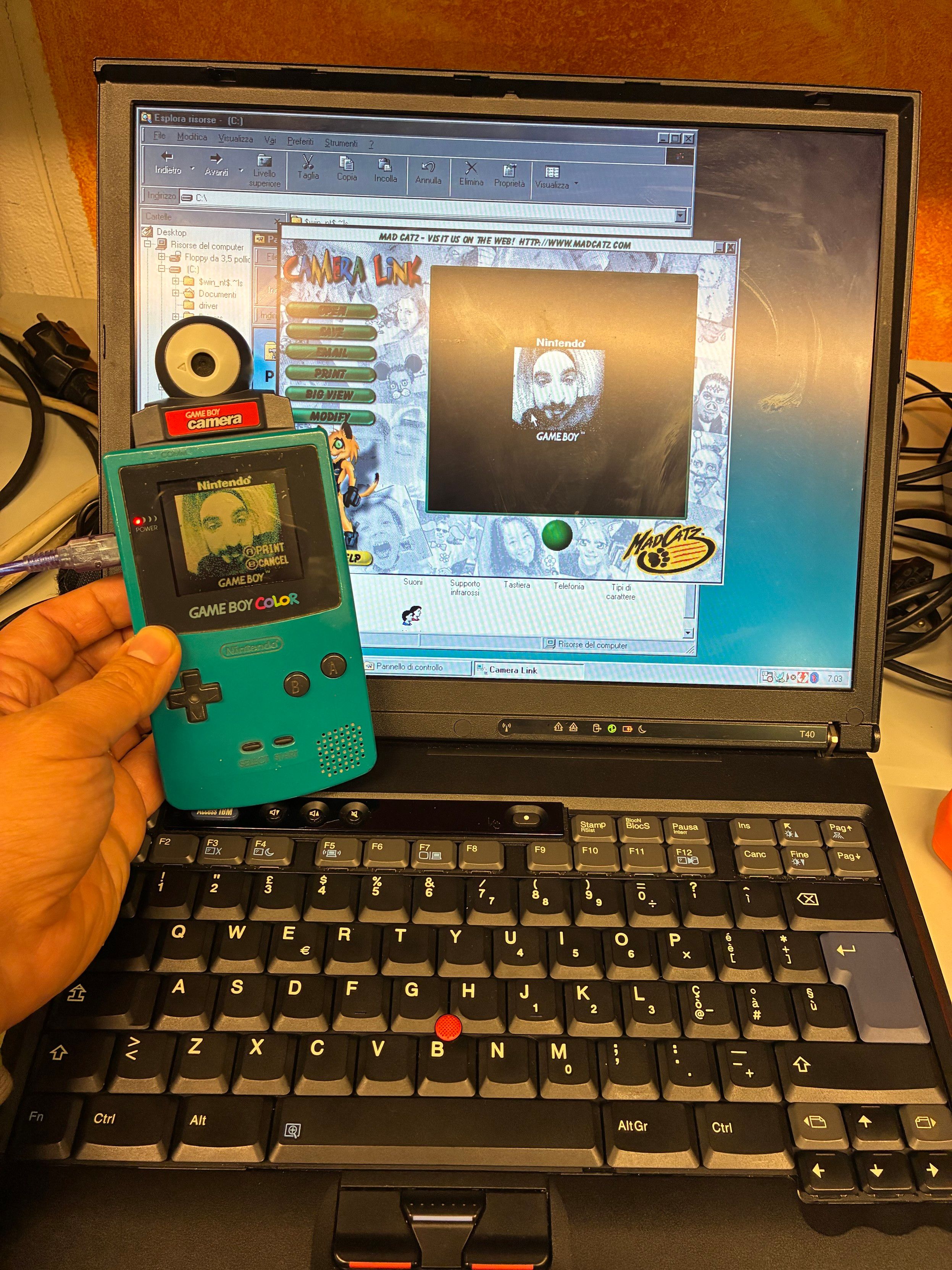 Un vecchio thinkpad t40 con collegato un gameboy color con un cavo madcatz camera link. Sul pc è aperto il software per scaricare le foto dal gameboy. 