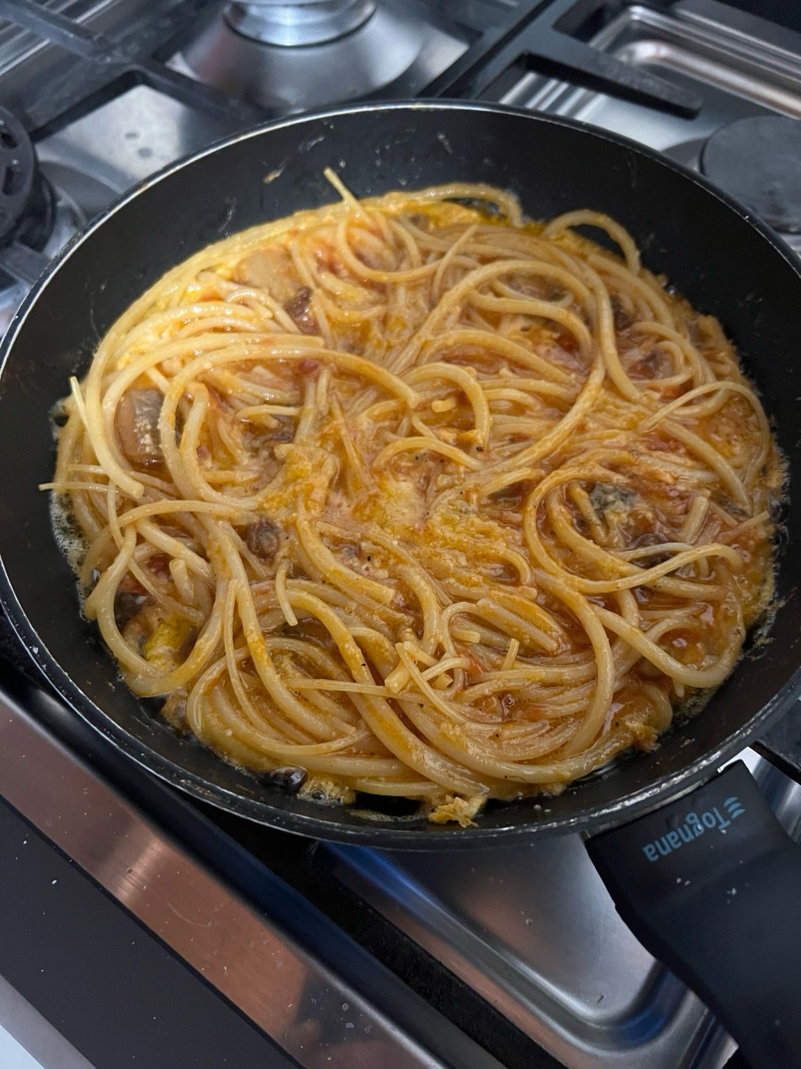 Frittata di spaghetti che cuoce nella padella