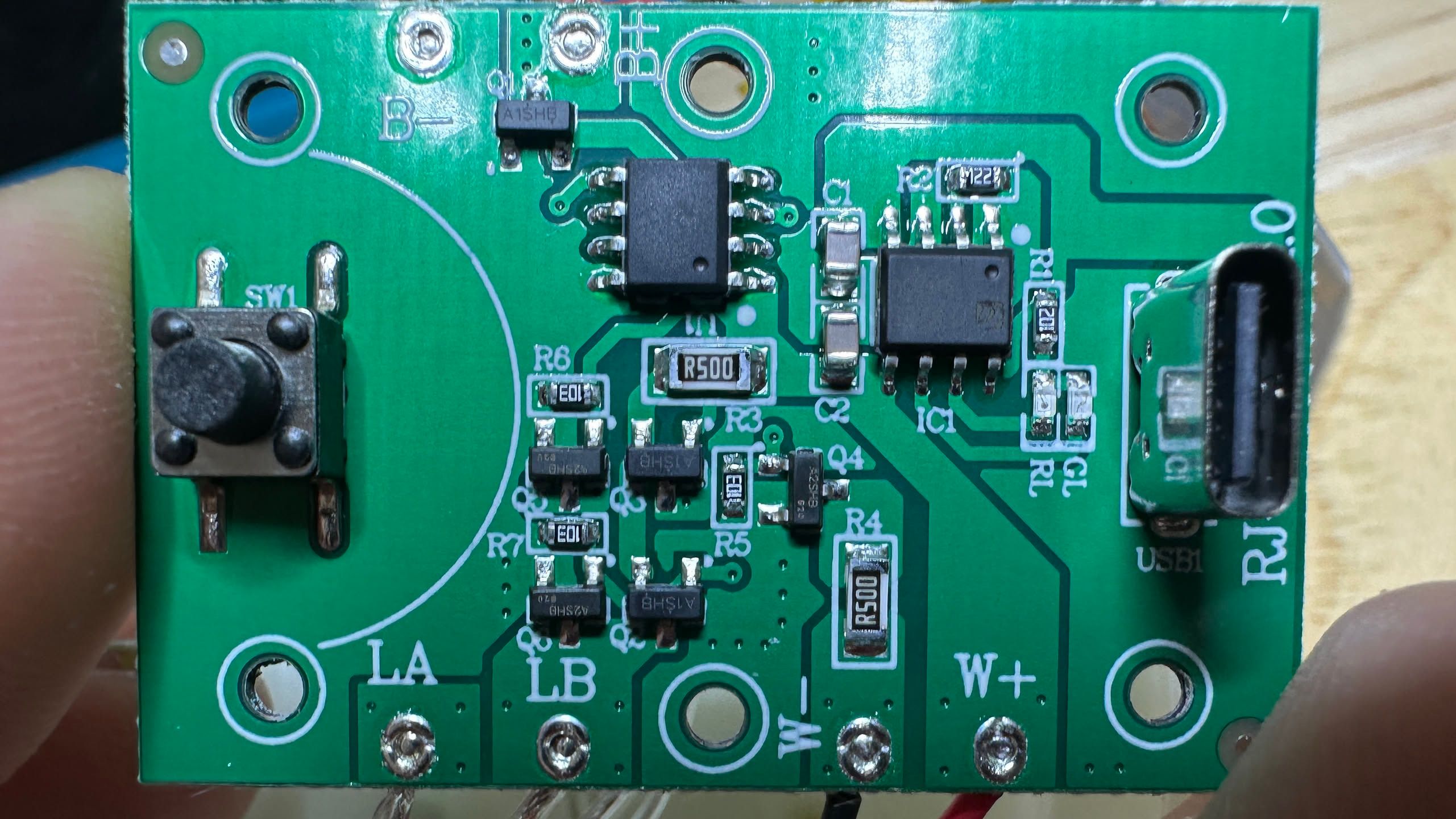 circuit board with two ICs that have their labels removed. one is a battery management and the other in an unknown SOIC-8 chip. a large R500 is in the center of the board.