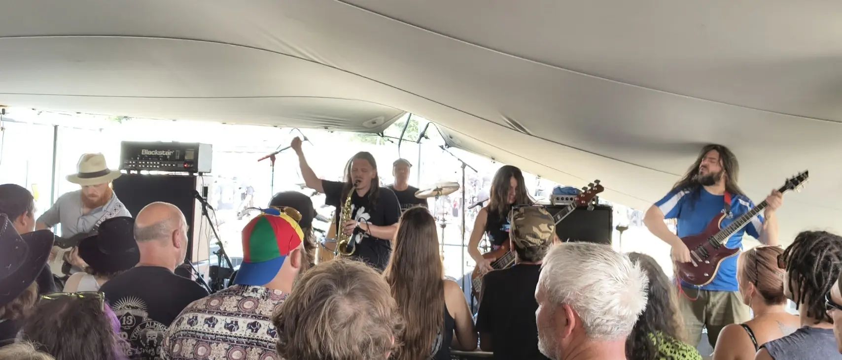 Z-Machine a 5 piece jazz fusion band. Featuring sax, guitar, bass, guitar, and drums on stage with a comically low ceiling