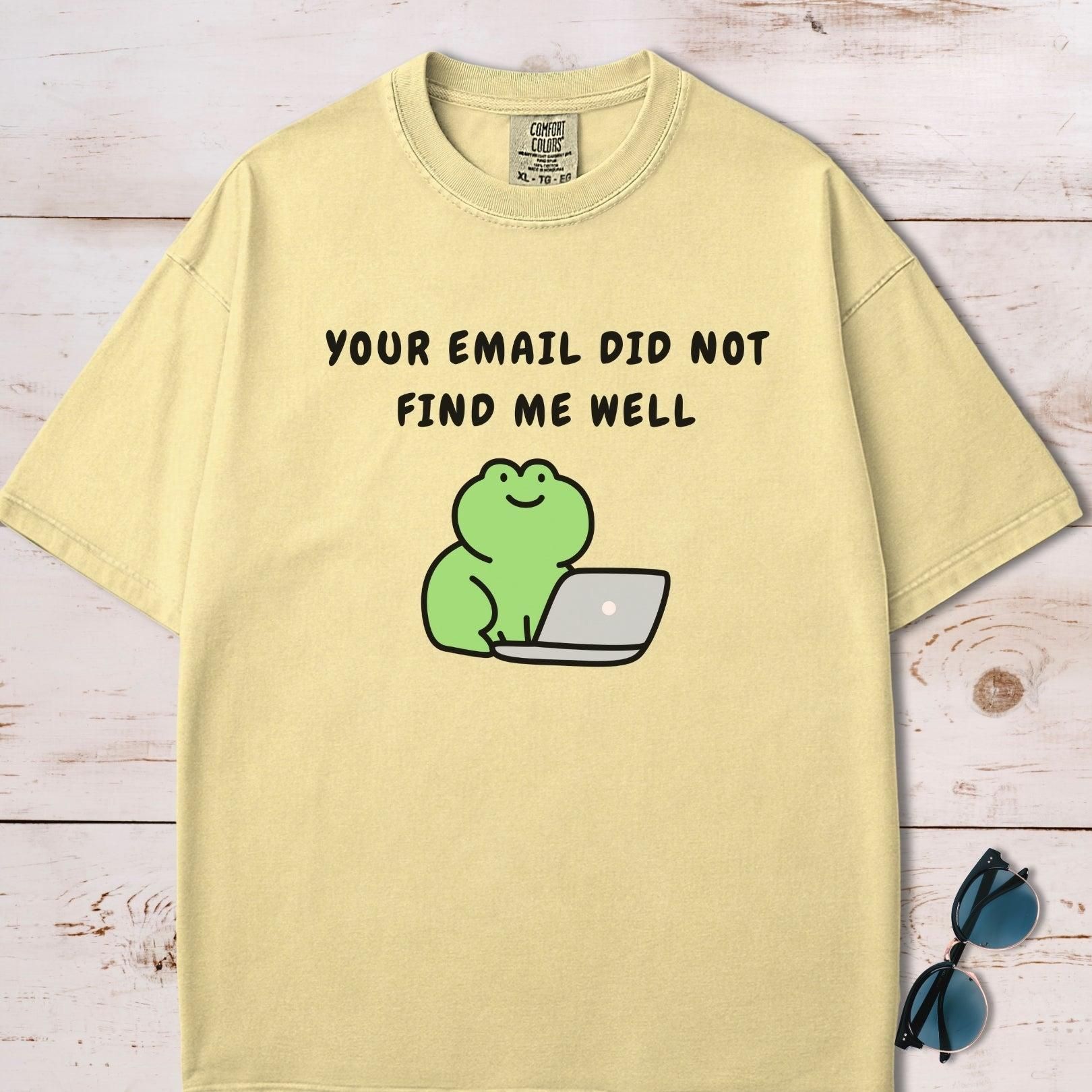 A yellow t-shirt featuring a cartoon green frog sitting at a laptop. Above the frog, text reads, "YOUR EMAIL DID NOT FIND ME WELL."