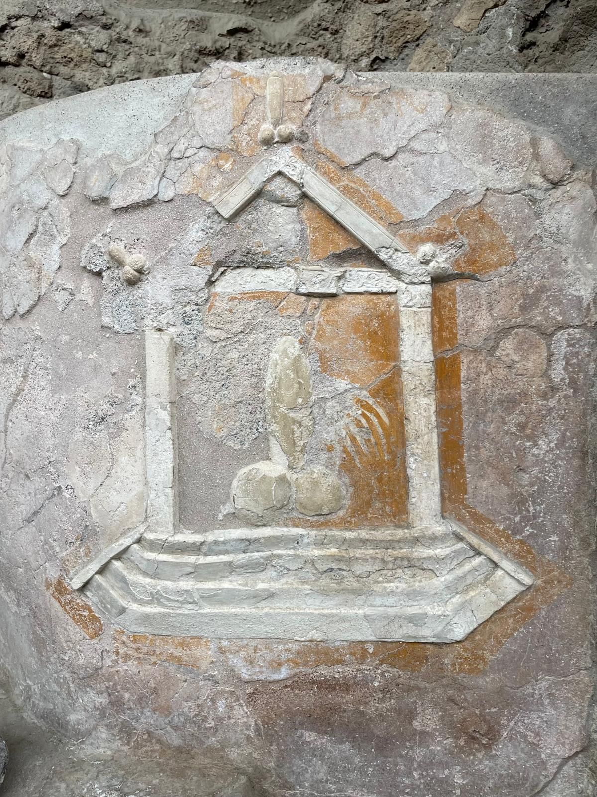 Immagine di un fallo contenuto in un'edicola, disegnata su una roccia. Indicava il lupanare. Agli angoli dell'edicola, altri piccoli falli