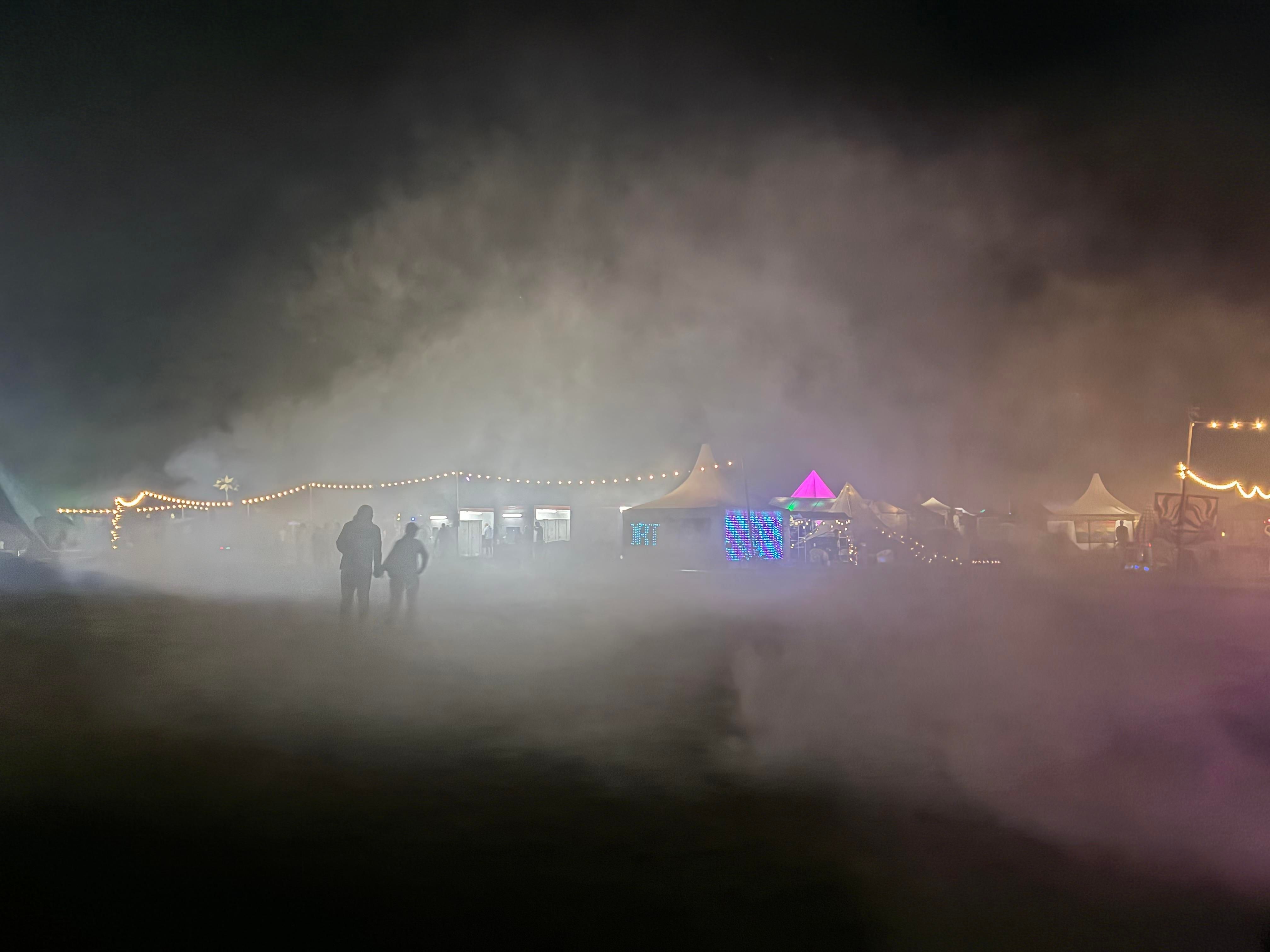 two people walking through the artificial smoke