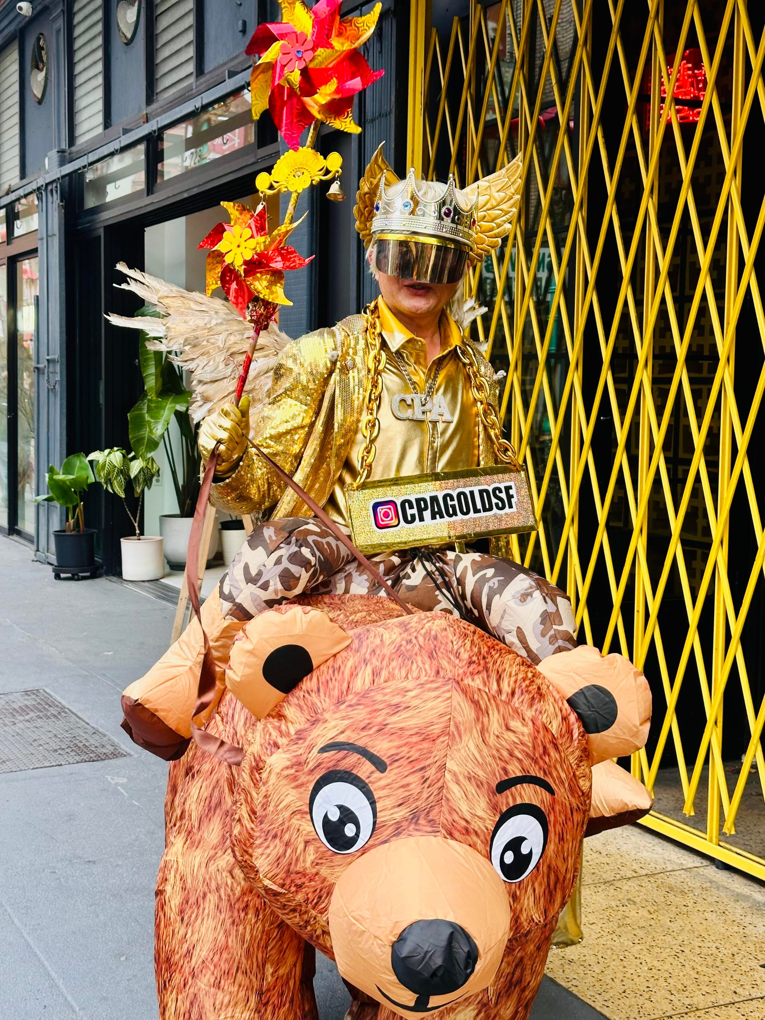 A photo of the CPA Gold guy riding a fake teddy bear 