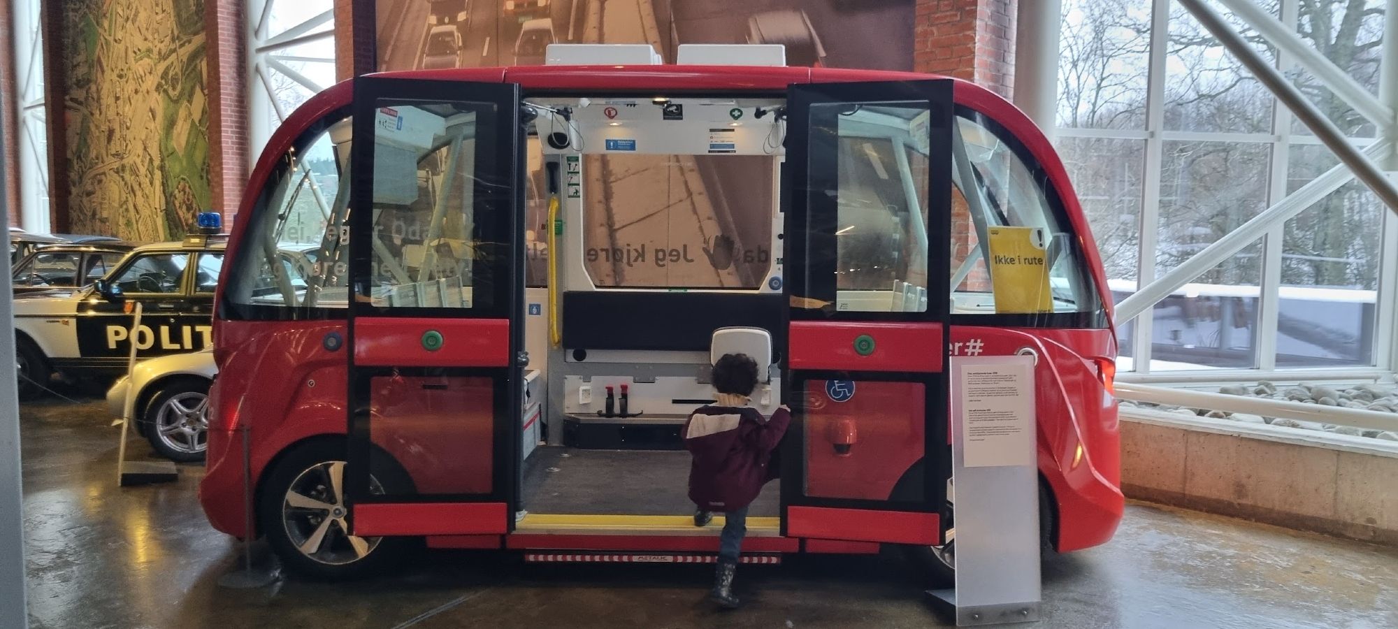 a picture of a red bus with seats on either side and no driver's compartment inside a museum 