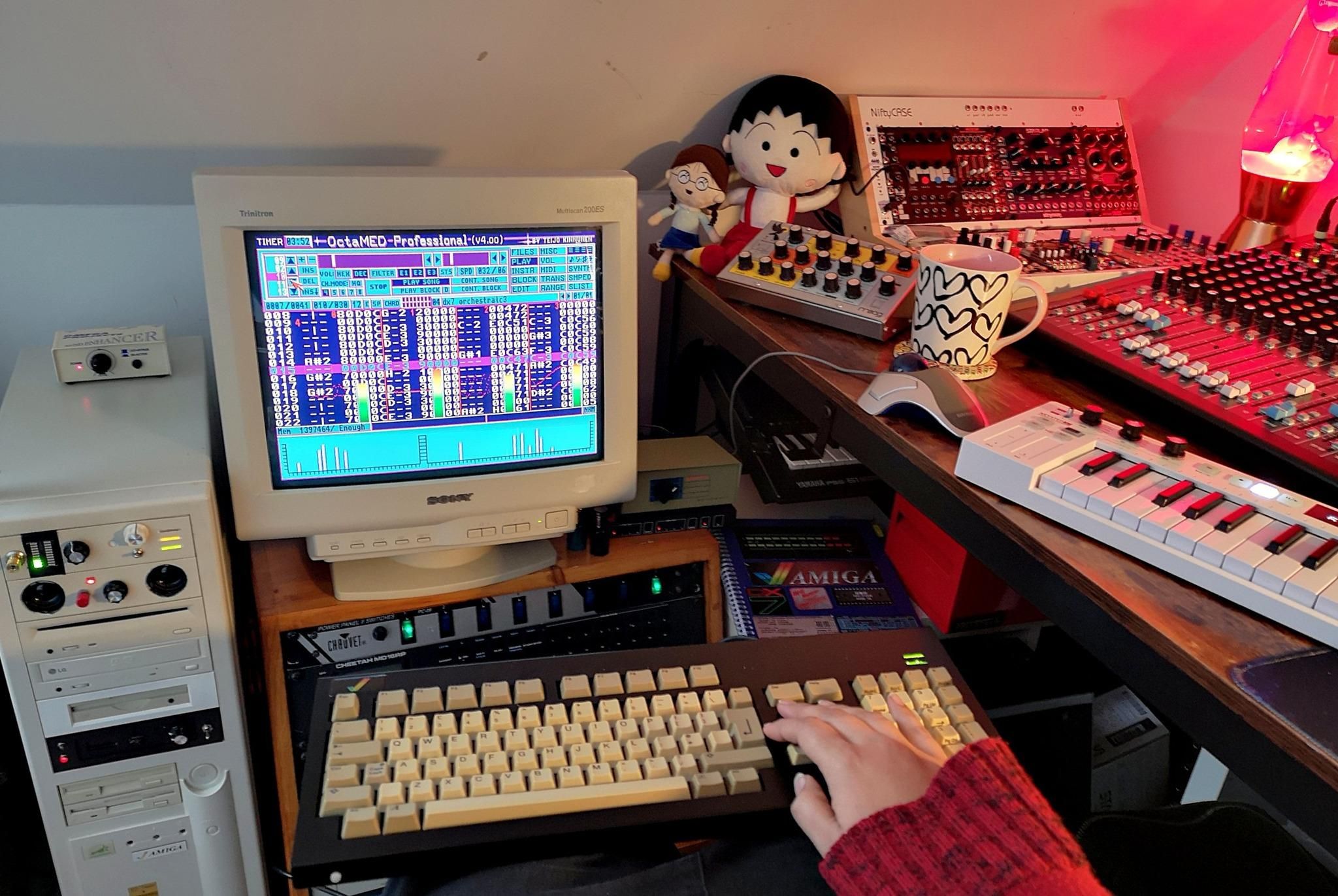 Amiga 1200 tower setup with CRT SVGA screen alongside a mixing desk and midi controller keyboard and synthesizers. in front of all this I have an Amiga keyboard on my lap.