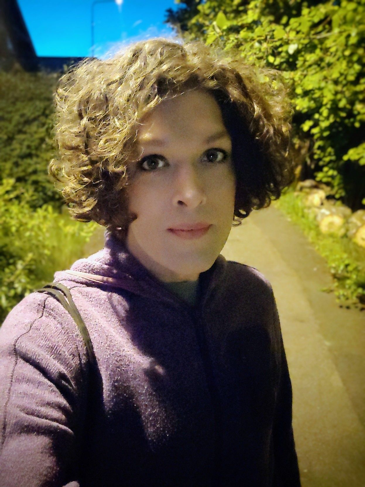 Out walking in the evening, smiling but looking a bit tired.