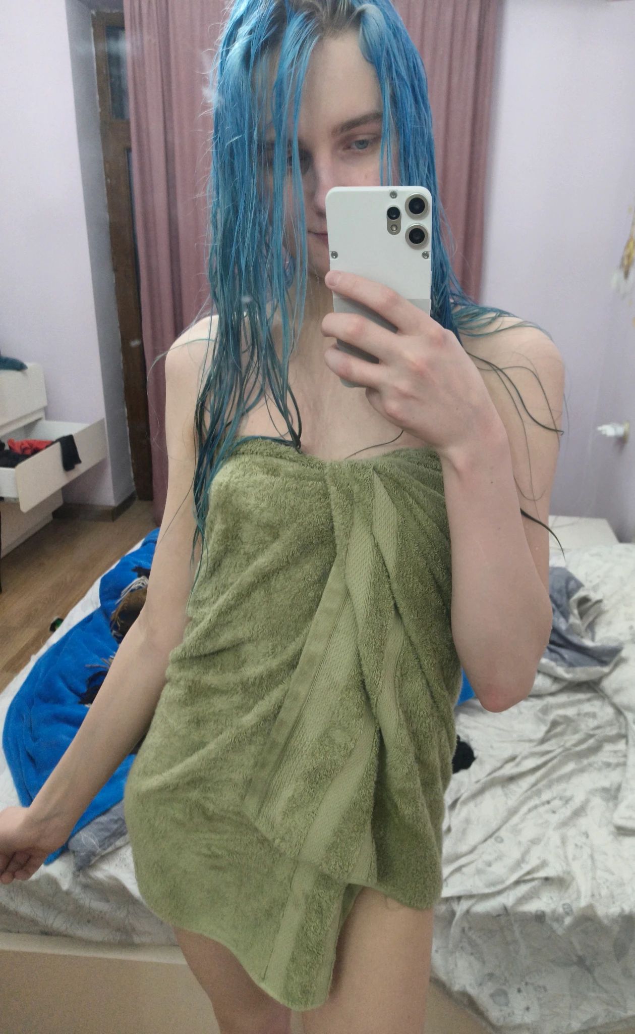 A mirror selfie of me with wet messy blue hair, wearing nothing except for a green towel