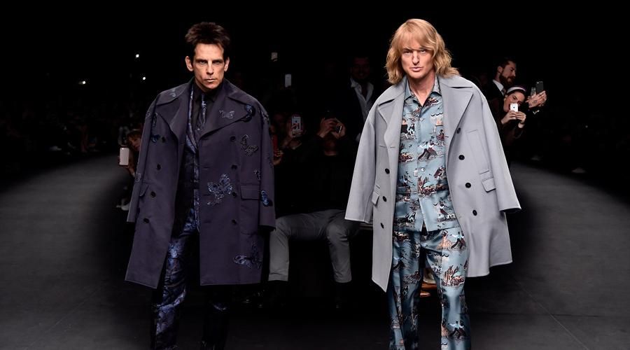 Photo of Derek Zoolander and Hansel. Two (fictional) fashion icons.

They are wearing fancy fashion outfits. They are also not putting their arms through the jacket sleeves of the jackets on their shoulders.