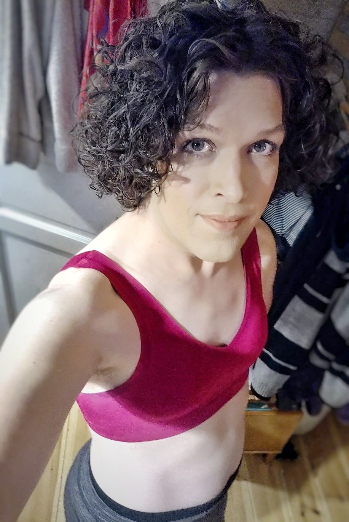 Me from above, smiling and looking into the camera. I'm wearing a pink bralette and grey leggings, but it's mostly just my upper body that's visible.