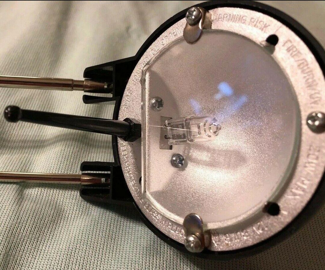 The head of the black model. A little fragile protrusion sticks out for head angle adjustment. The thing has lots of warnings about it getting hot and the protective glass. Not a prob when replaced with LED bulb.