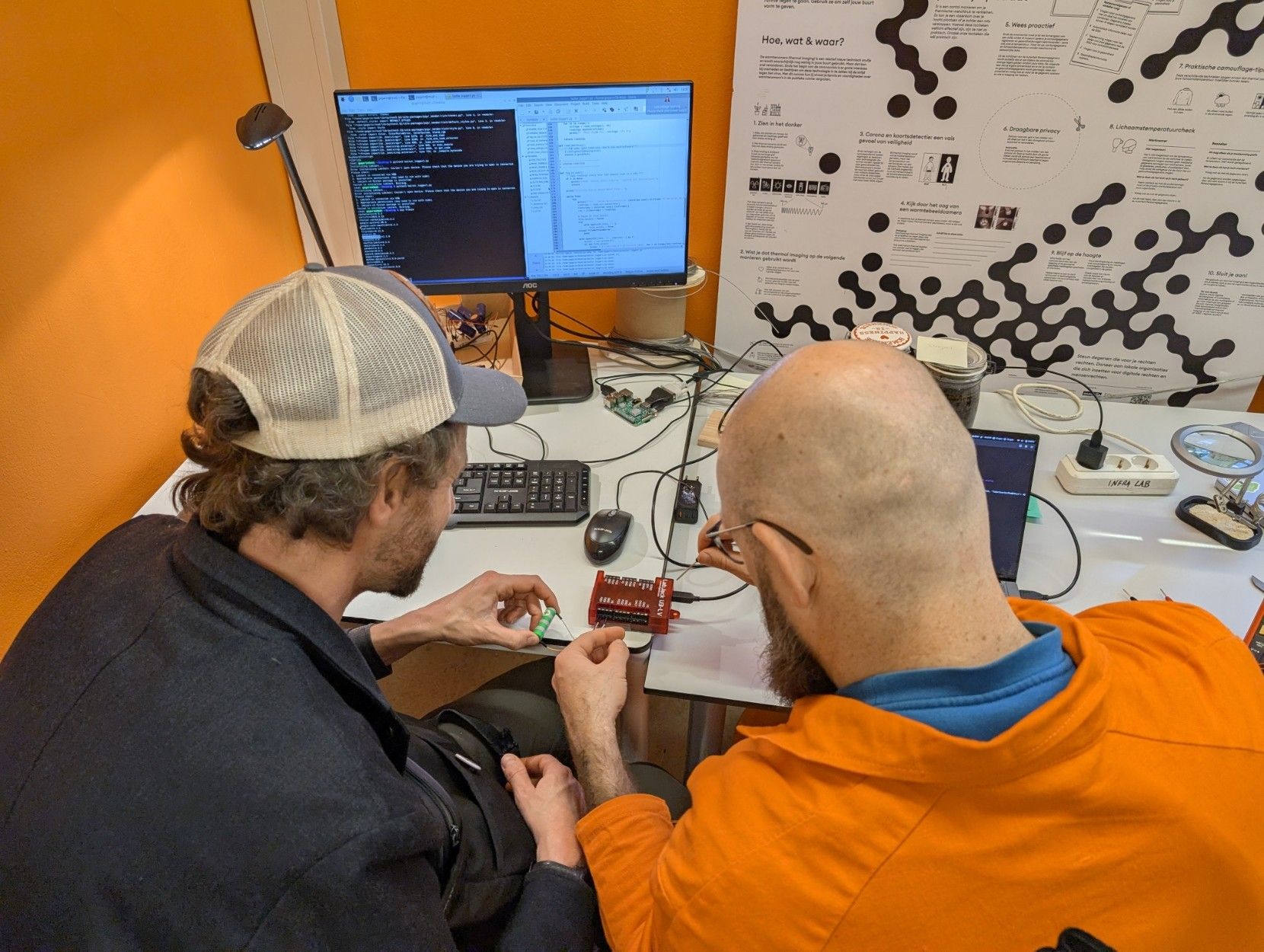 The back of two people connecting wires together