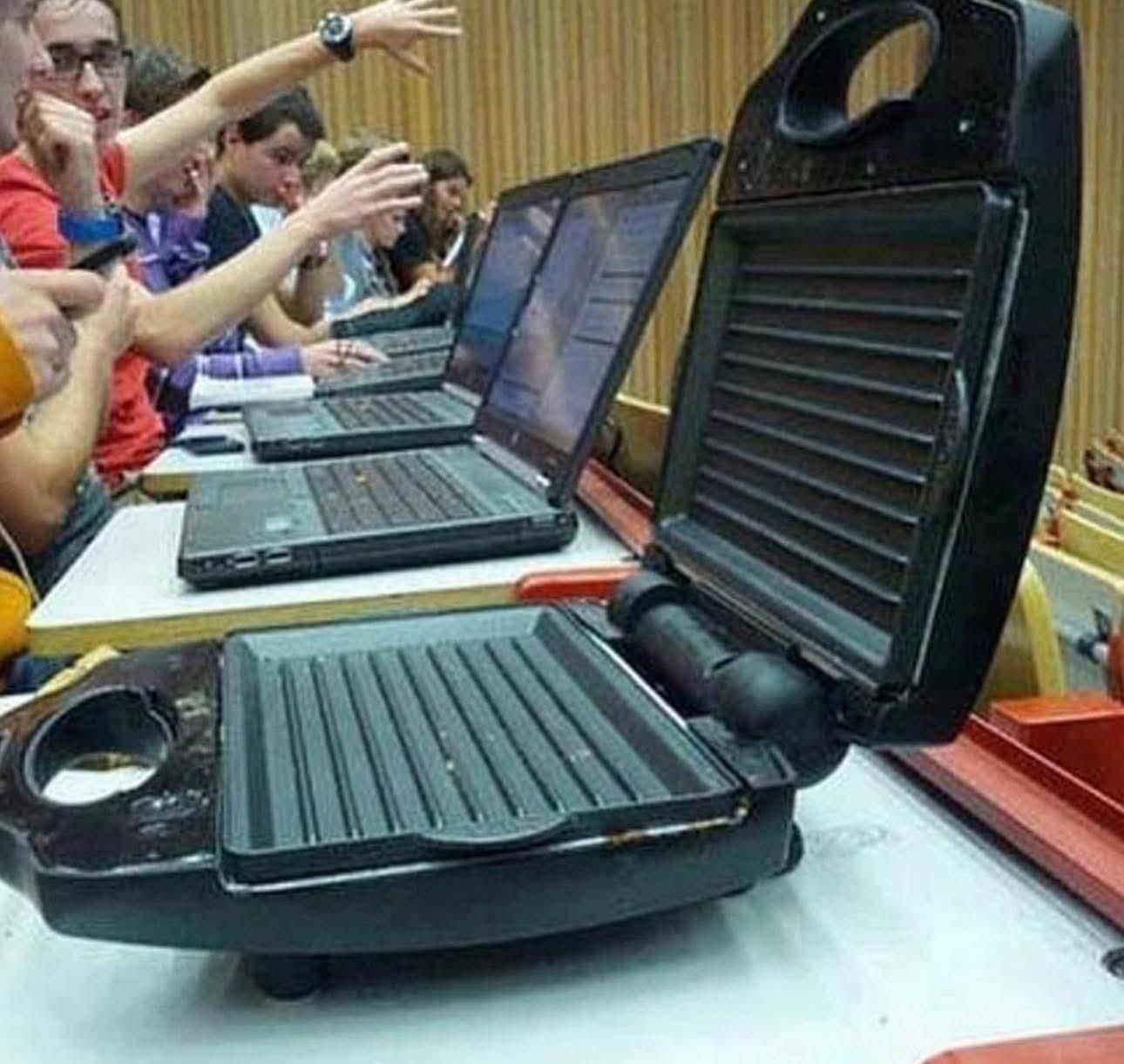 an angled shot showing students working with their laptops, except the first thing in front is actually an electric grill