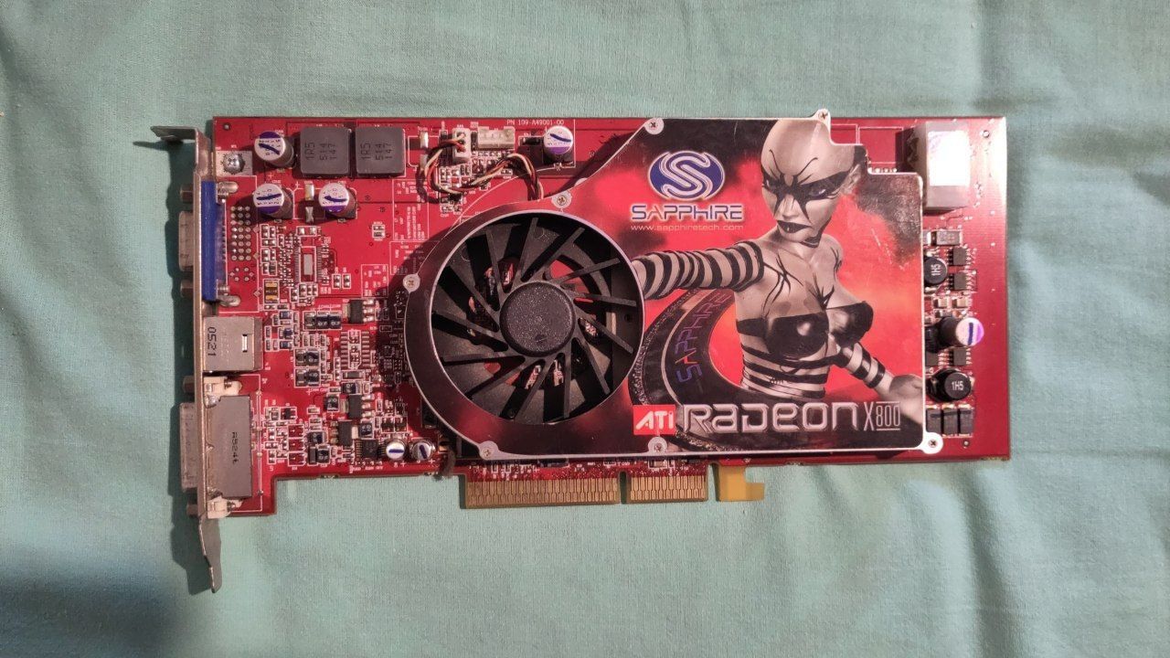Una scheda video Radeon X800 di inizio anni 2000, con la board rossa e una grafica 3D impressa sulla scocca del radiatore