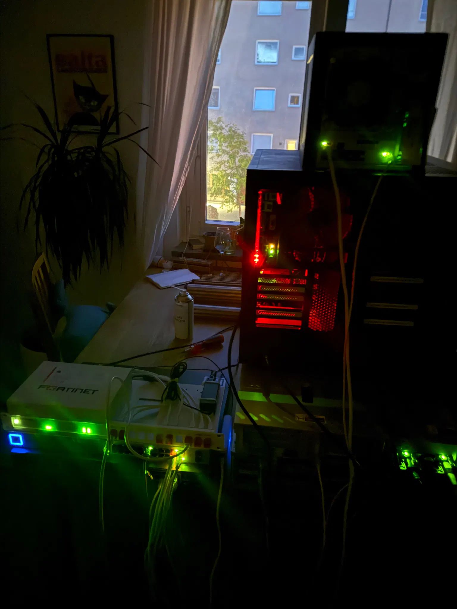 a long exposure picture taken of a bunch of computers sitting on a table, the room is dark but a lot of small lights on the computers are visible in the darkness, some shine brighter than others