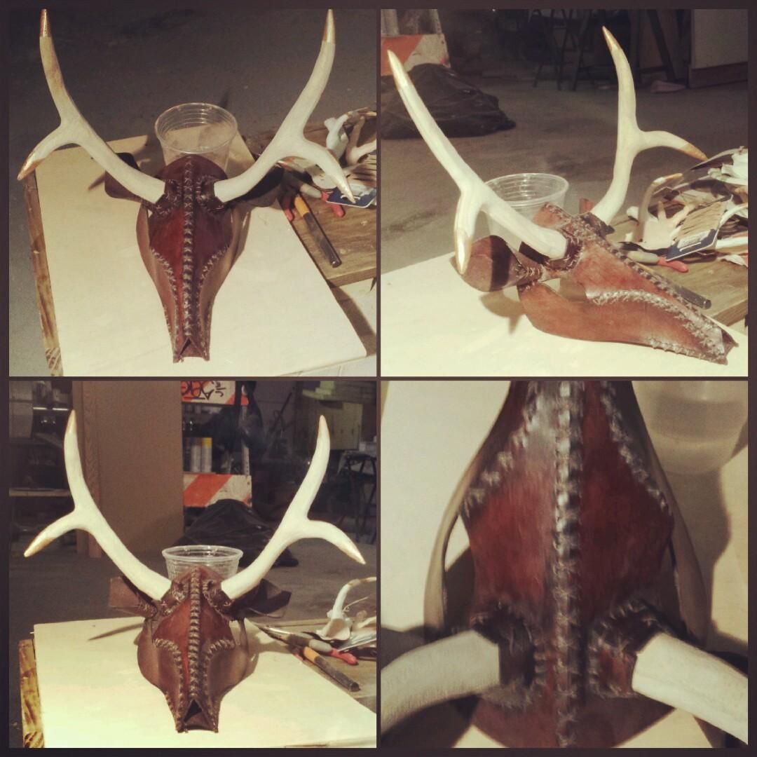Close-ups of the deer mask showing white-painted wooden antlers with gold -tips