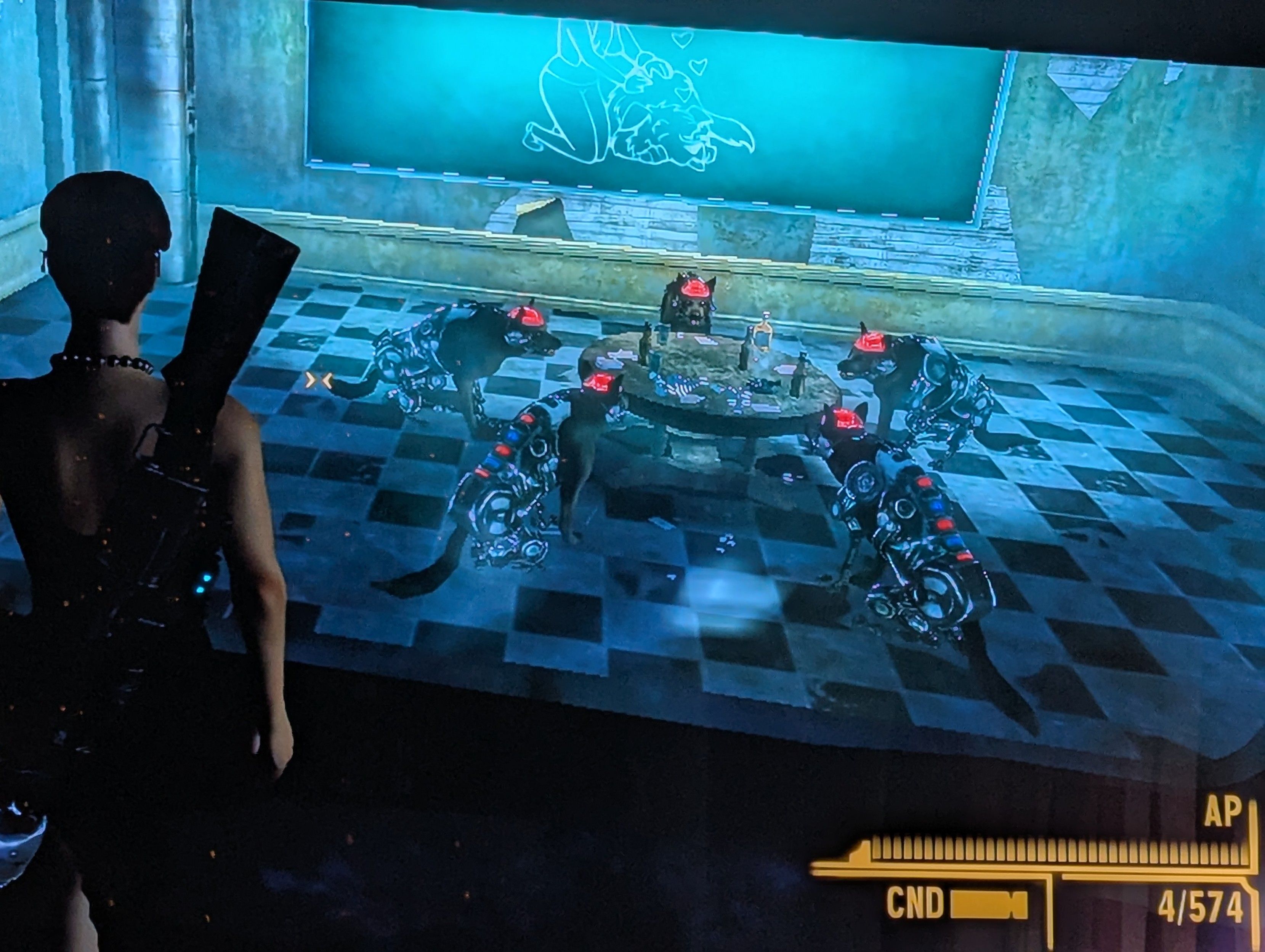 Fallout New Vegas gameplay image. We see the back of a woman in a black party dress with a red beret carrying a large energy weapon rifle in her back. She is looking through an observation window, the back of a one way mirror. Inside the observation room we see a chalkboard and checkered floor tiles. It resembles a classroom with common American 1950s retro aesthetics. Five robot dogs with glowing red brains sit around a table in the center of the room. The table has cards and cigars and liquor bottles on it. 

This is a recreation of the classic "dogs playing poker" painting