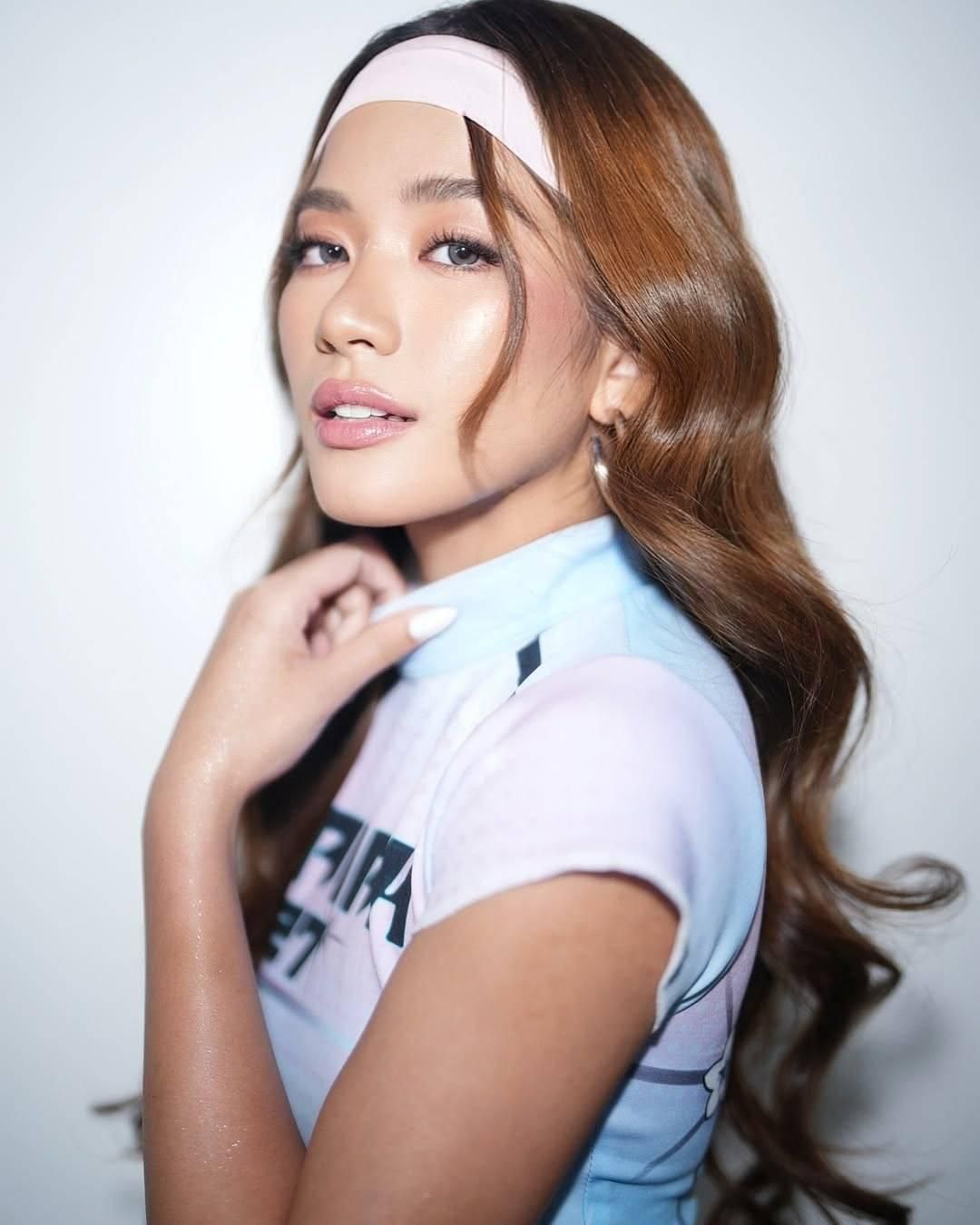 Aiah Arceta of Bini. Side view, wearing white head band and white t-shirt