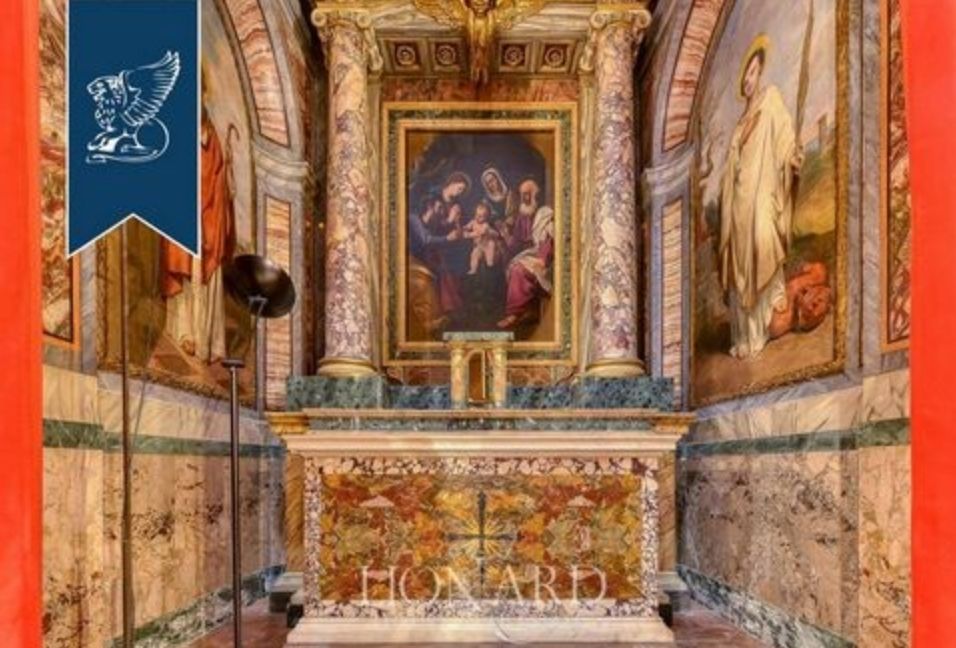 What looks like an old altar in a narrow room, and the walls and altar are covered in medieval style paintings of saints and Jesus and family above the altar. It is made of marble, as are the bottom parts of the walls.