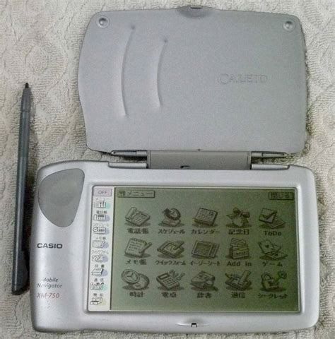 A photograph of a landscape-mode touchscreen-based Japanese computer/organiser called Casio Mobile Navigator XM-750, showing three rows of application icons