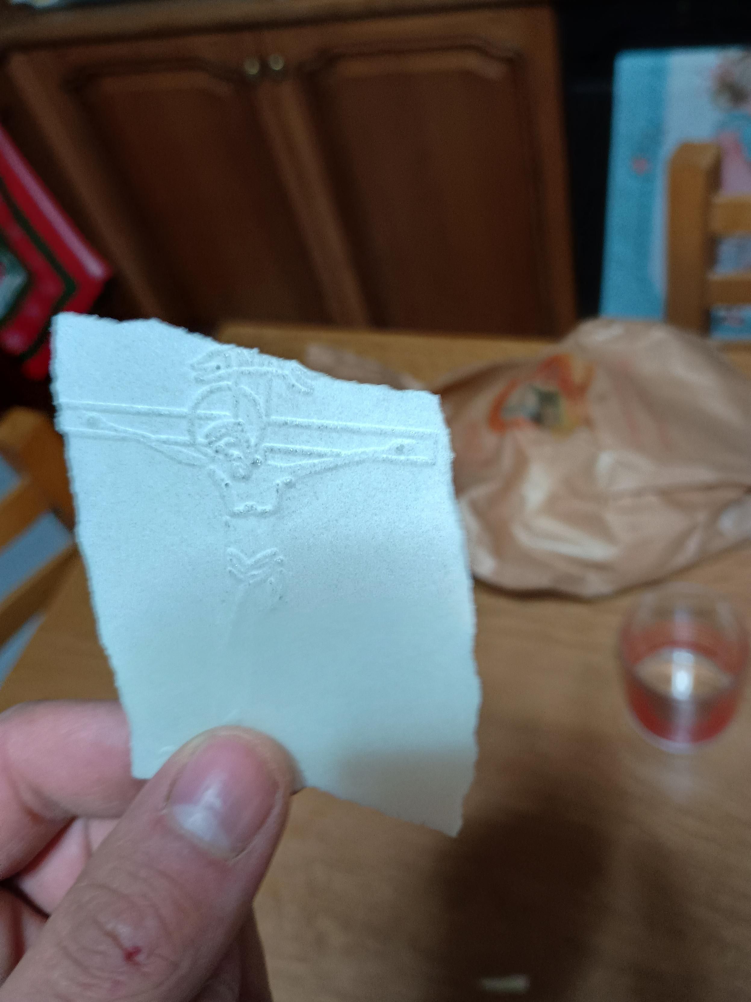 Mano con ostia non consacrata con l'immagine di Gesù sulla croce