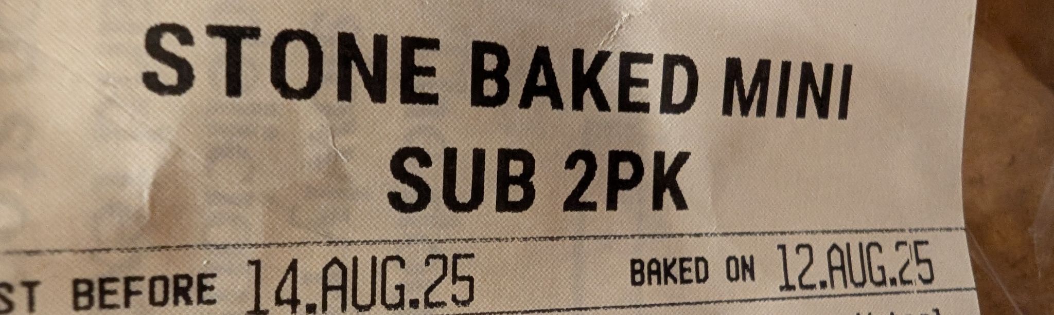 Cropped photo of food package label which reads:
"STONE BAKED MINI SUB 2PK"
"[BE]ST BEFORE 14.AUG.25" - "BAKED ON 12.AUG.25"