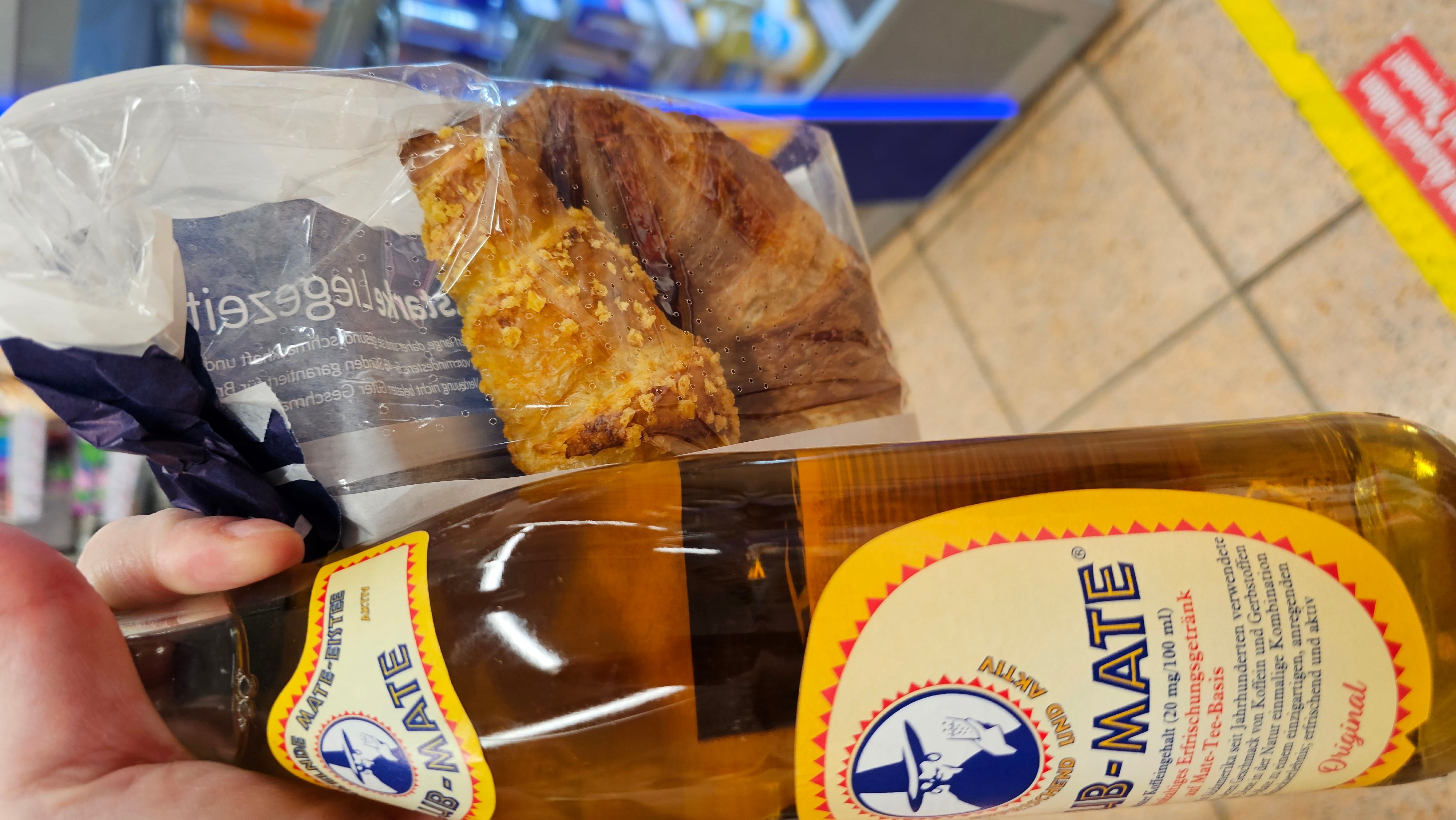 Foto von einer Flasche Club-Mate und einer Papiertüte mit Gipfeli