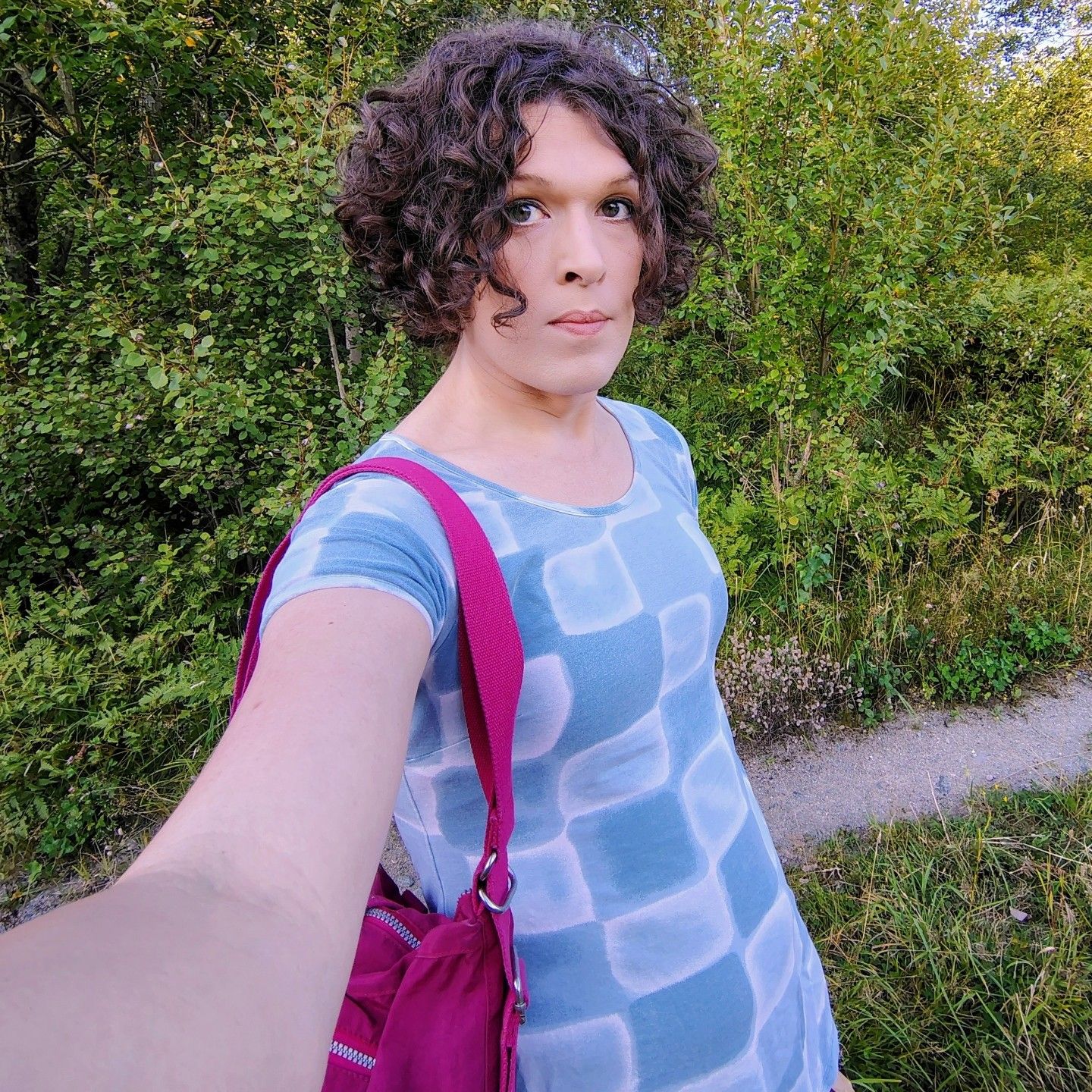 selfie on a dirt road through the forest, slate grey dress and red bag