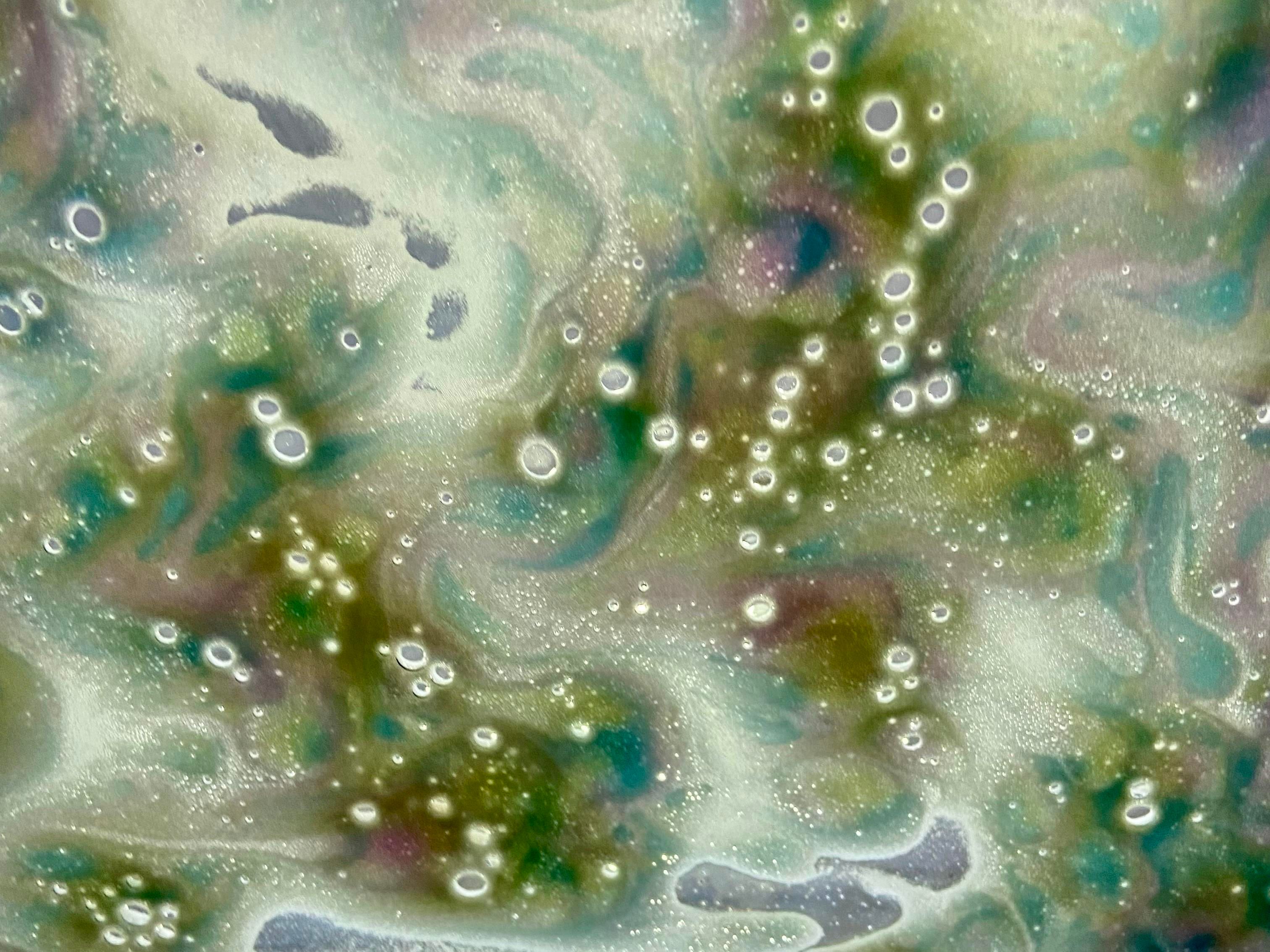 Bubbly foam on my car's windshield during the car wash with the tri-color option. Swirls of blue, yellow, and pink, combining to form turquoise and Chartreuse. 