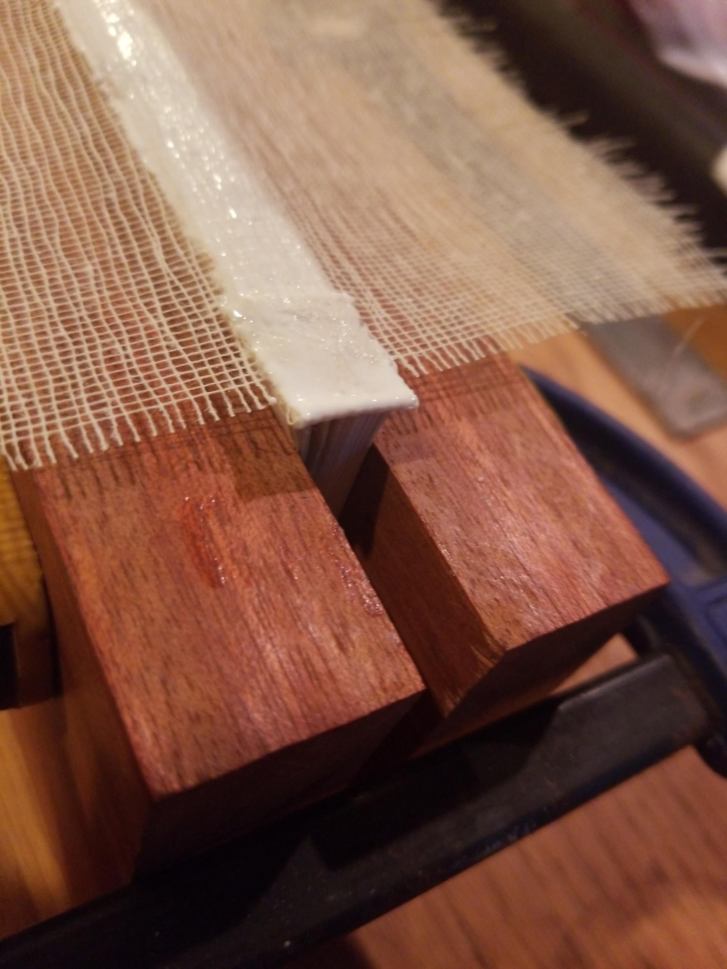 Several signatures of paper clamped between hardwood planks with glue and support mesh 