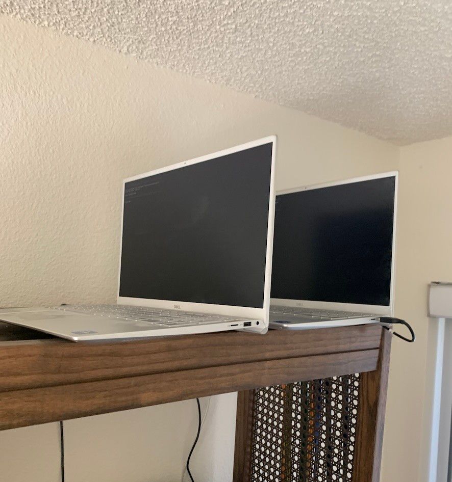 Two laptops on a high shelf