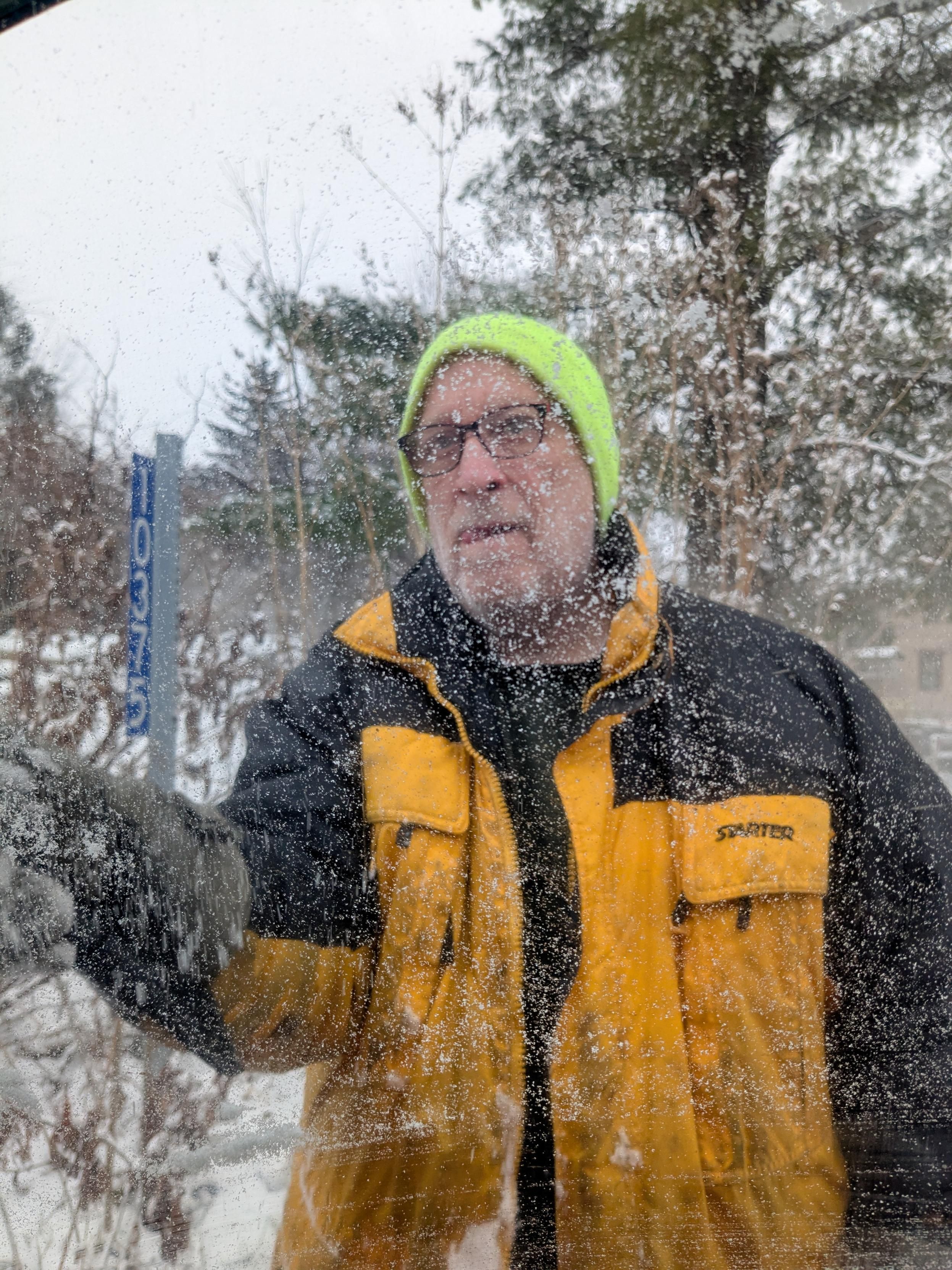A man in a yellow jacket in the snow 