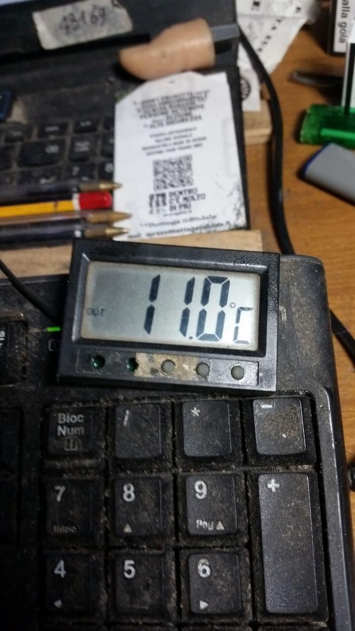 Termometro appoggiato sopra la tastiera, segna 11℃.