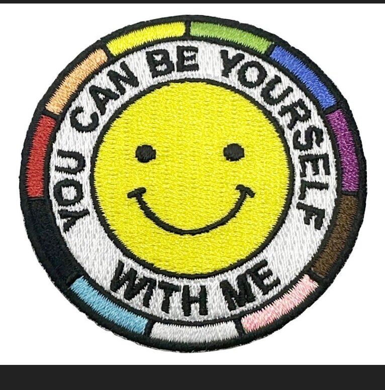 A happy yellow smiley face inside "You can be yourself with me" text, inside an LGBT+ spectrum.