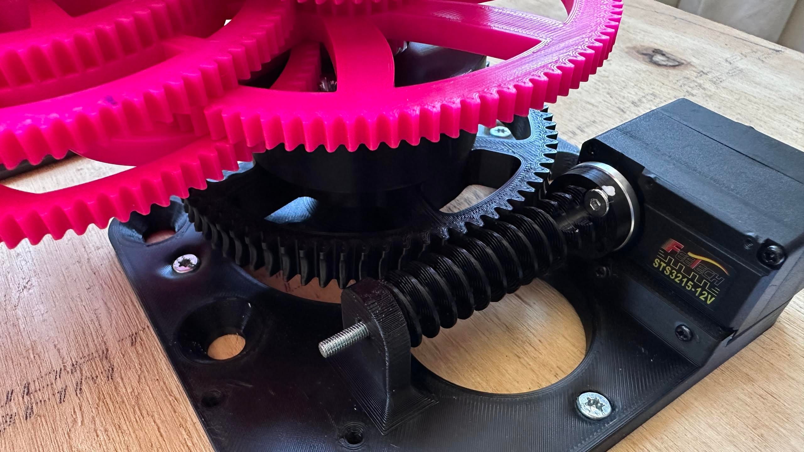 closeup of a servo with a worm gear driving a helical gear, mounted on a wooden board