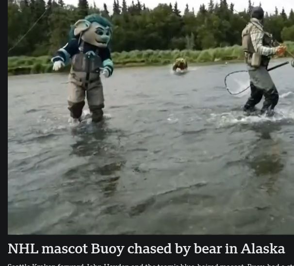 Man in a ridiculous costume being chased by a grizzle