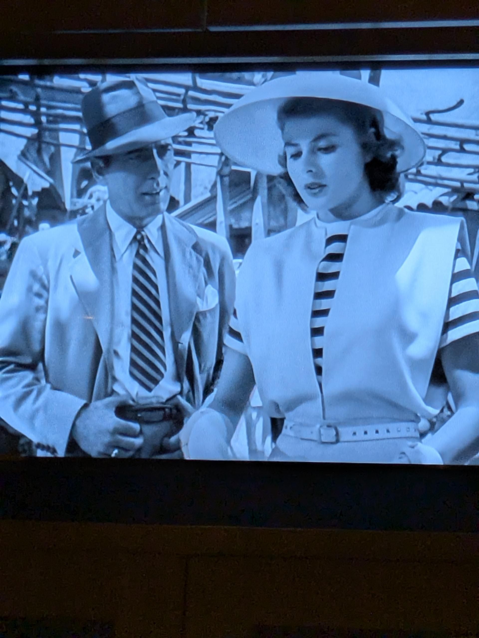 A shot from Casablanca.  Rick wearing striped tie and a white jacket, Ilsa wearing a striped top under a white jacket.  