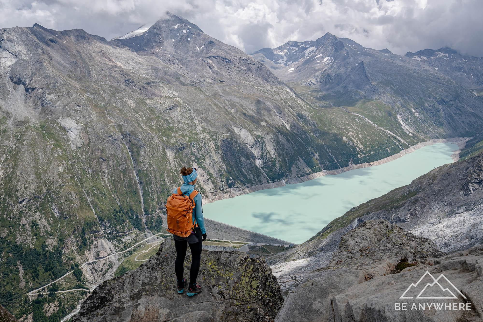 Woman standing on a rock high above a mountain lake.
