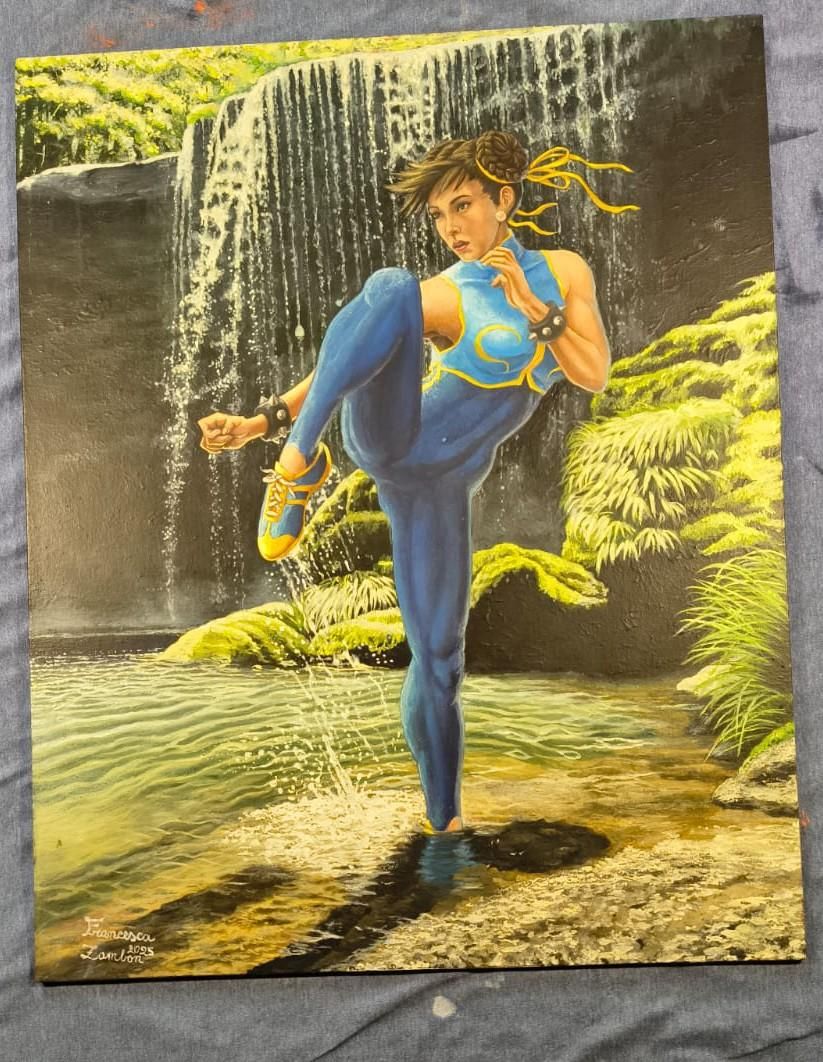 Una ragazza muscolosa carica un calcio con la gamba destra alzata, in equilibrio sulla gamba sinistra tesa. Indossa una tuta aderente blu con una giacchetta corta in stile cinese e delle scarpe da ginnastica blu e gialle. La Ragazza è in uno stagno, circondata da piante a foglia verde e acqua, con una piccola cascatella alle spalle. Il piede sinistro è immerso nell'acqua fino alla caviglia.