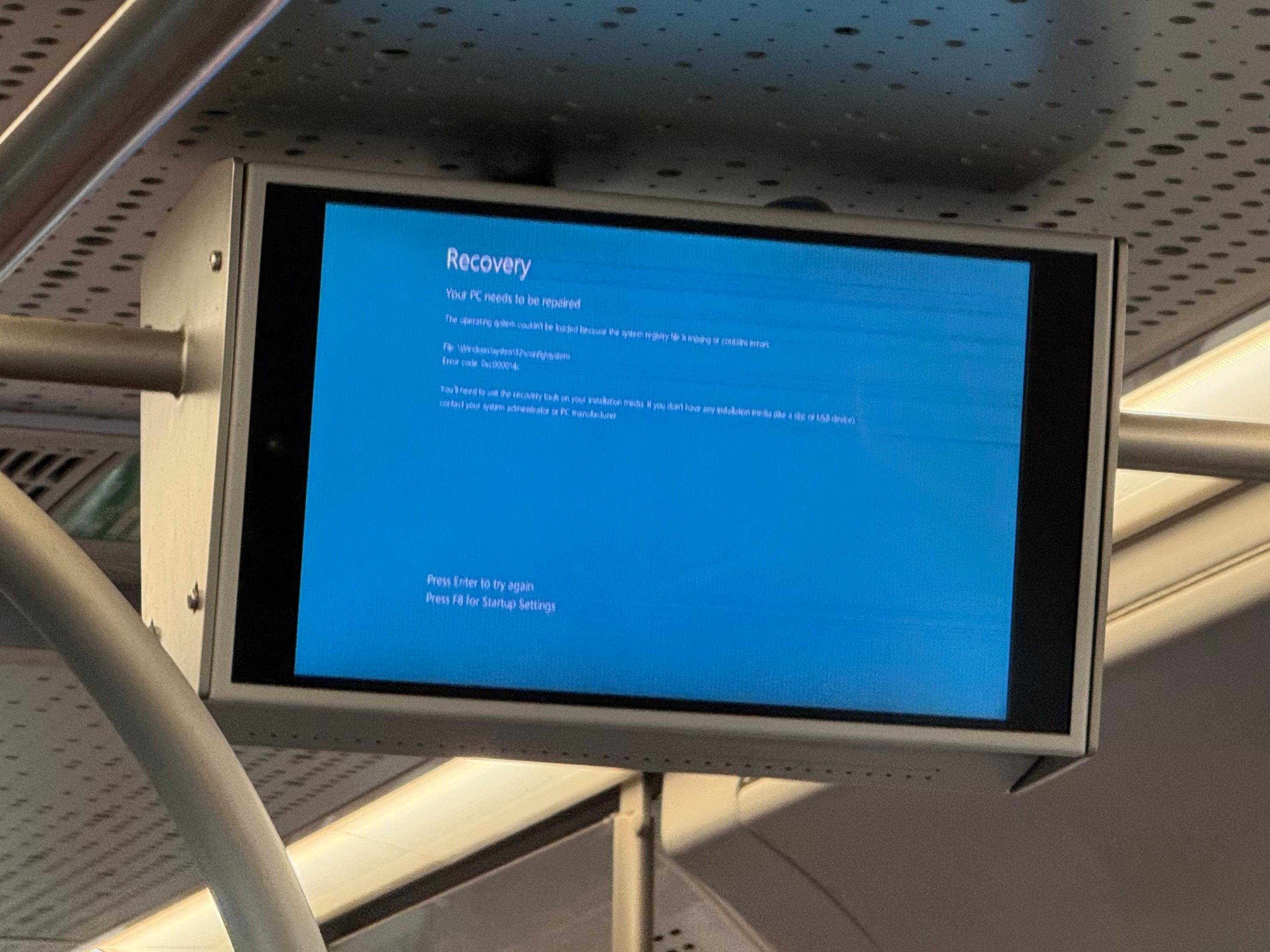 Photo of the heads up display on an airport shuttle bus. It shows the Windows 10(?) “Your PC needs to be repaired” recovery screen